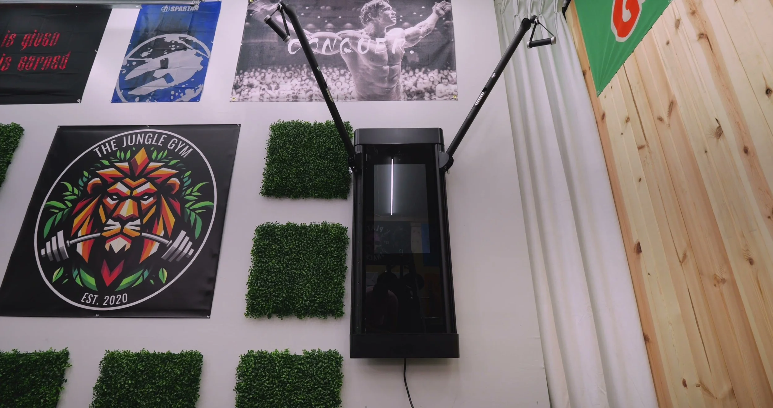 The Tonal 2 smart home gym mounted on a wall with adjustable arms extended