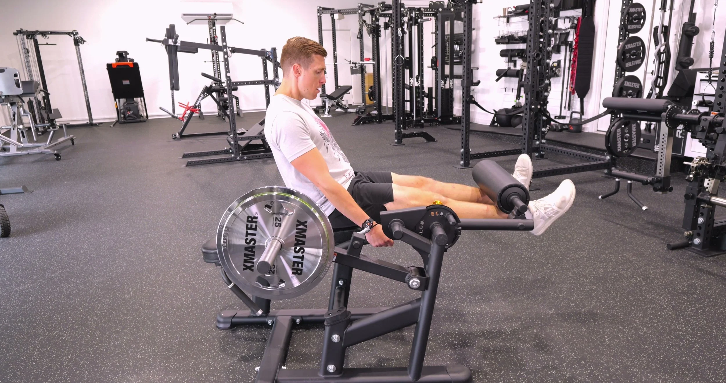 Michael performing a seated leg extension on the Legion Fitness LELC machine