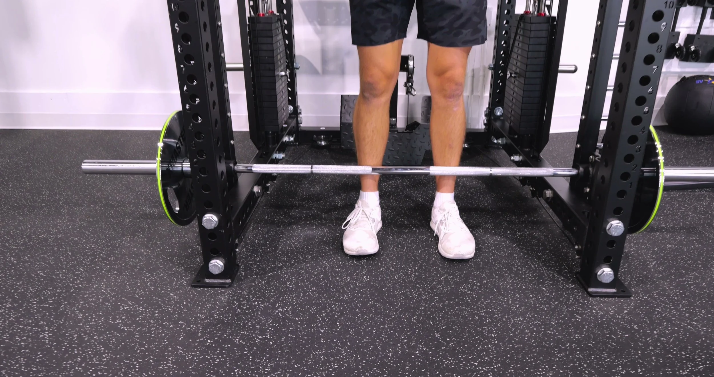 The offset Smith Machine bar and safety stoppers on the outside of the rack