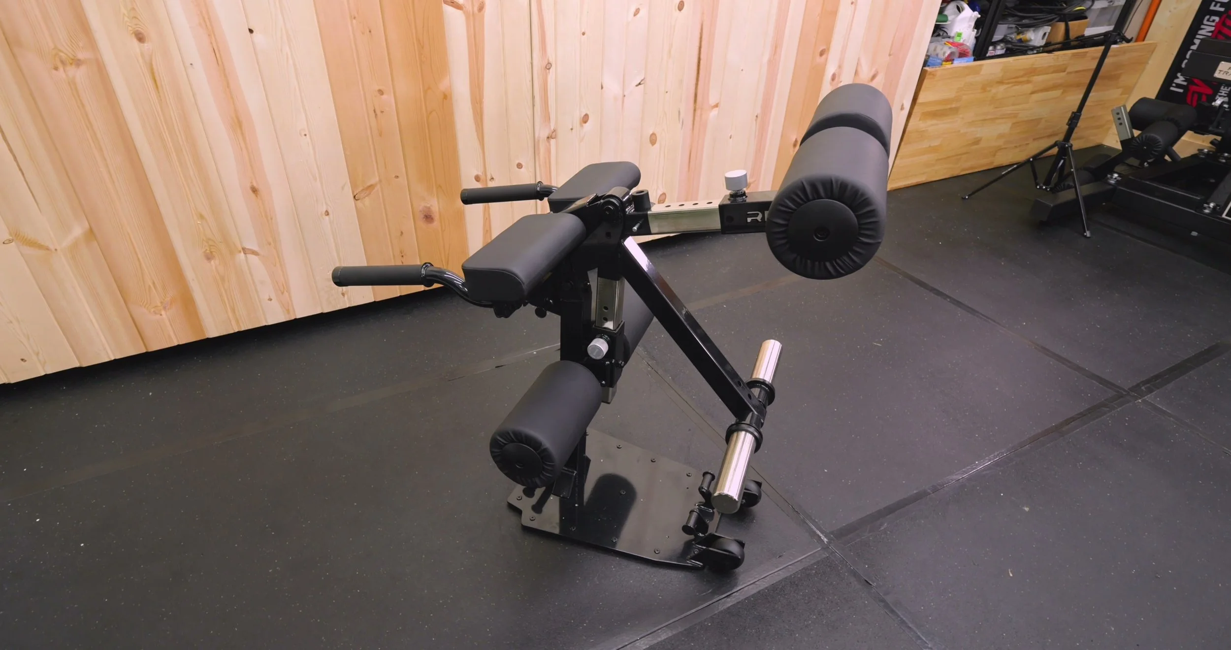 rep leg extension attachment stored upright off bench in home gym