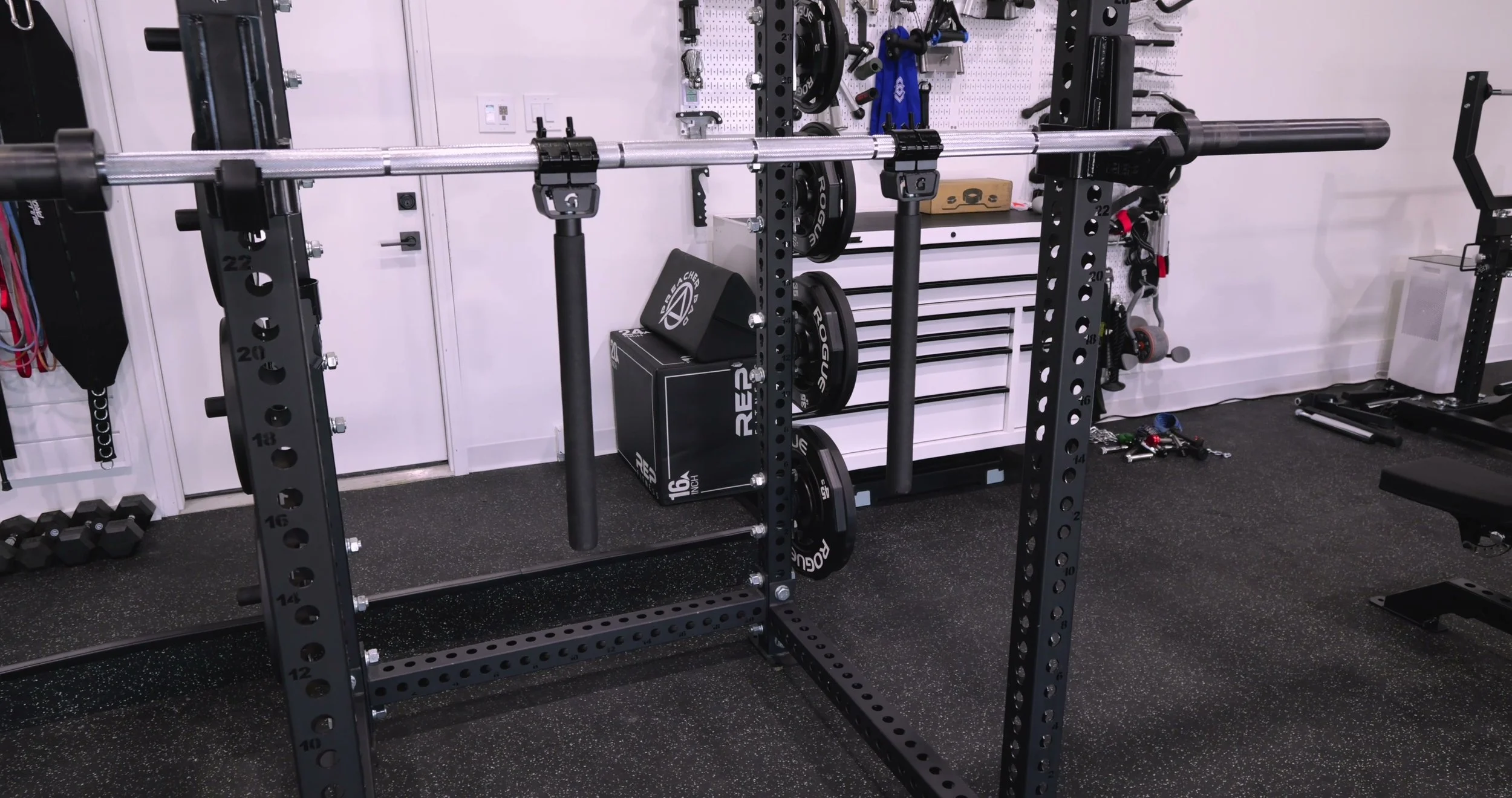 GymPin Safety Squat Handles attached to a barbell on a rack