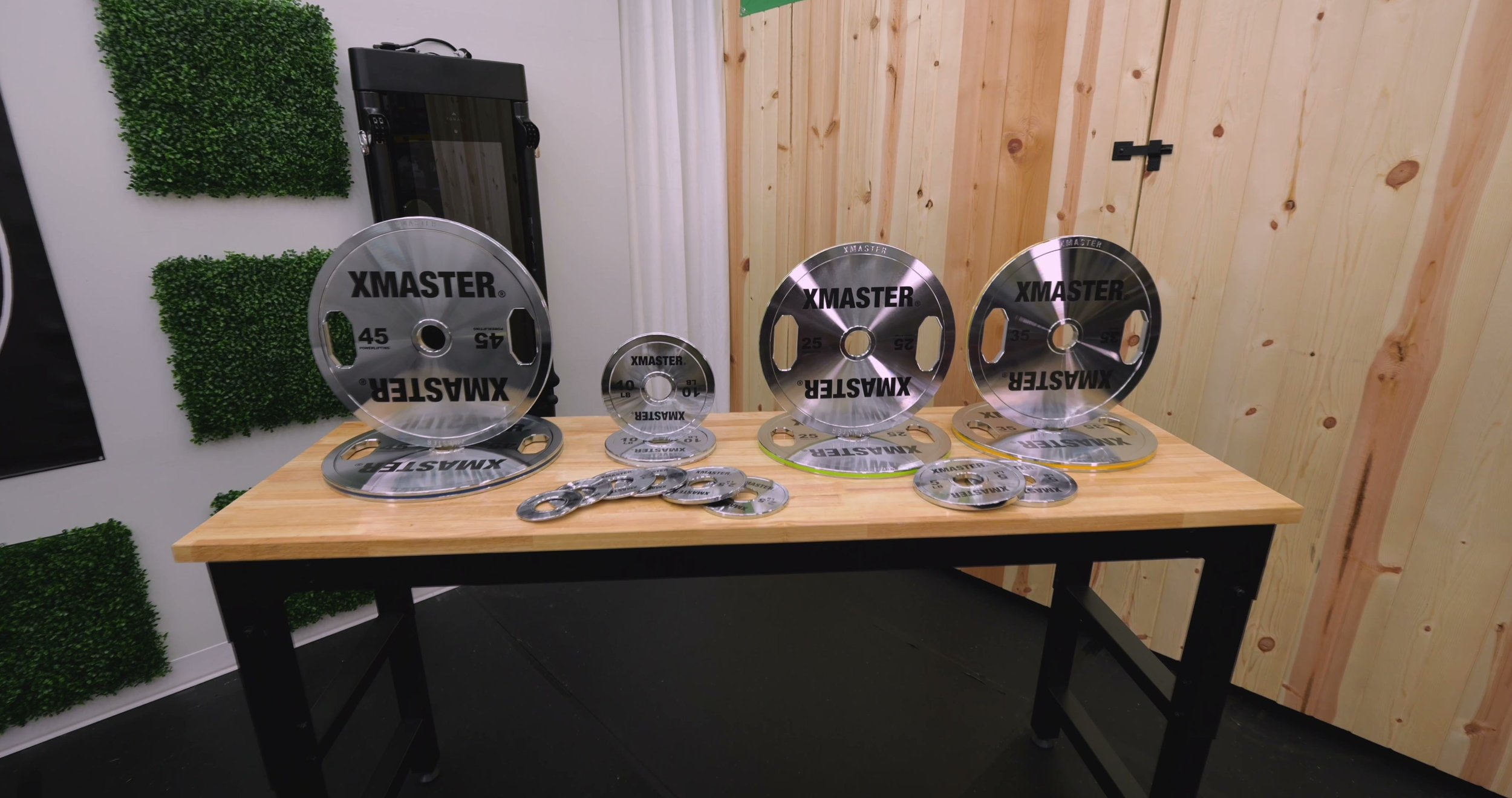 A full set of XMaster Chrome Steel Plates and Change Plates stacked in a home gym