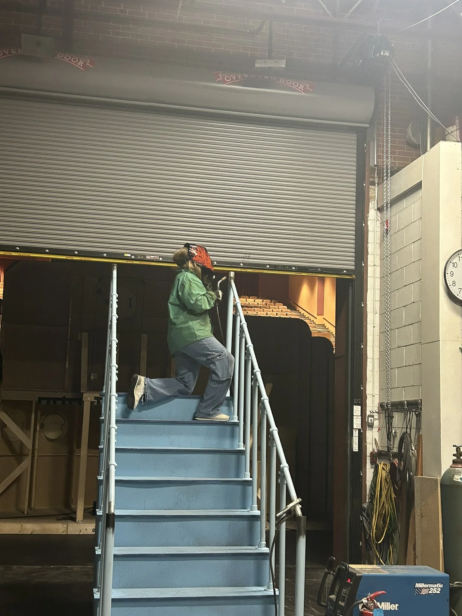 Painting the railing while the technical director does welding notes