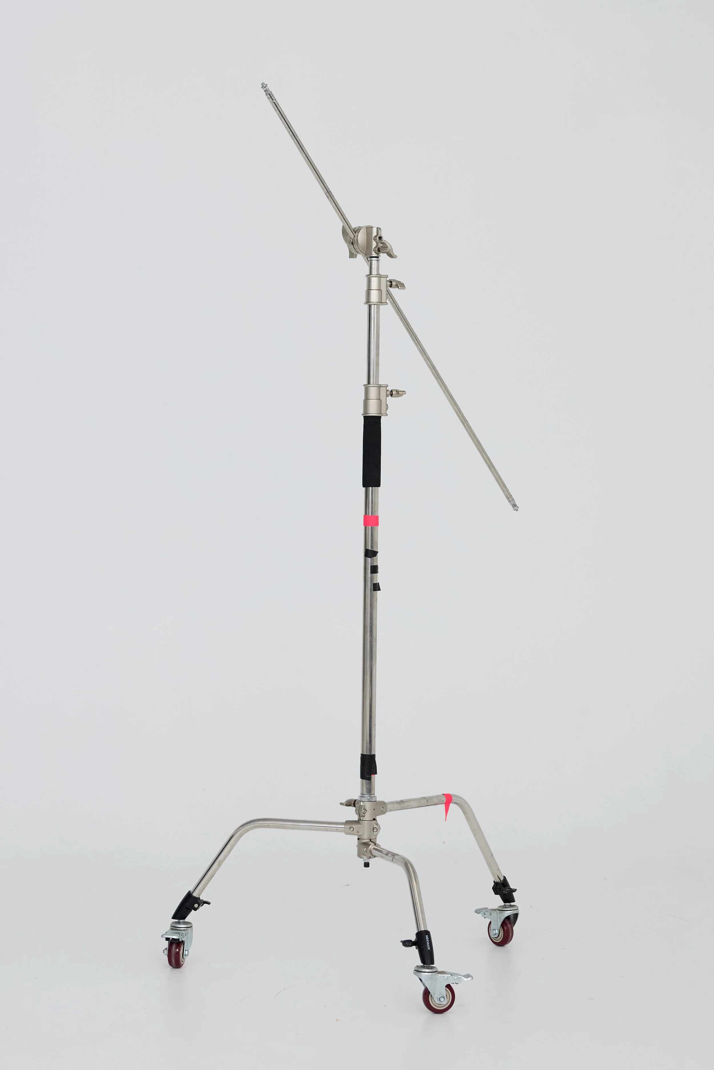A professional-grade adjustable salon boom arm light stand on wheels with metal construction, black and pink details, and an extended arm with a monitor or light attachment.
