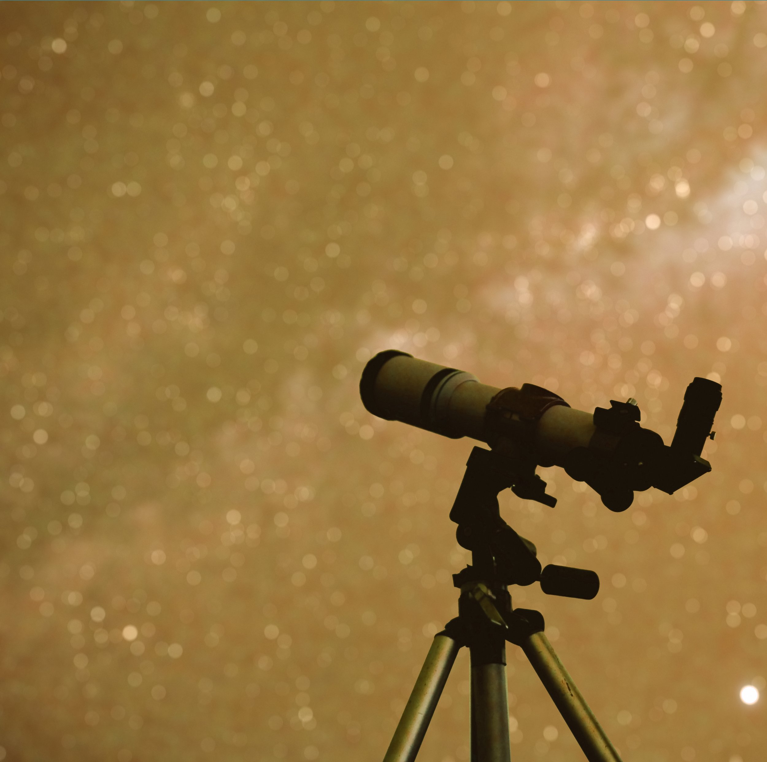 Silhouette of a telescope on a tripod against a starry night sky with a galaxy in the background.
