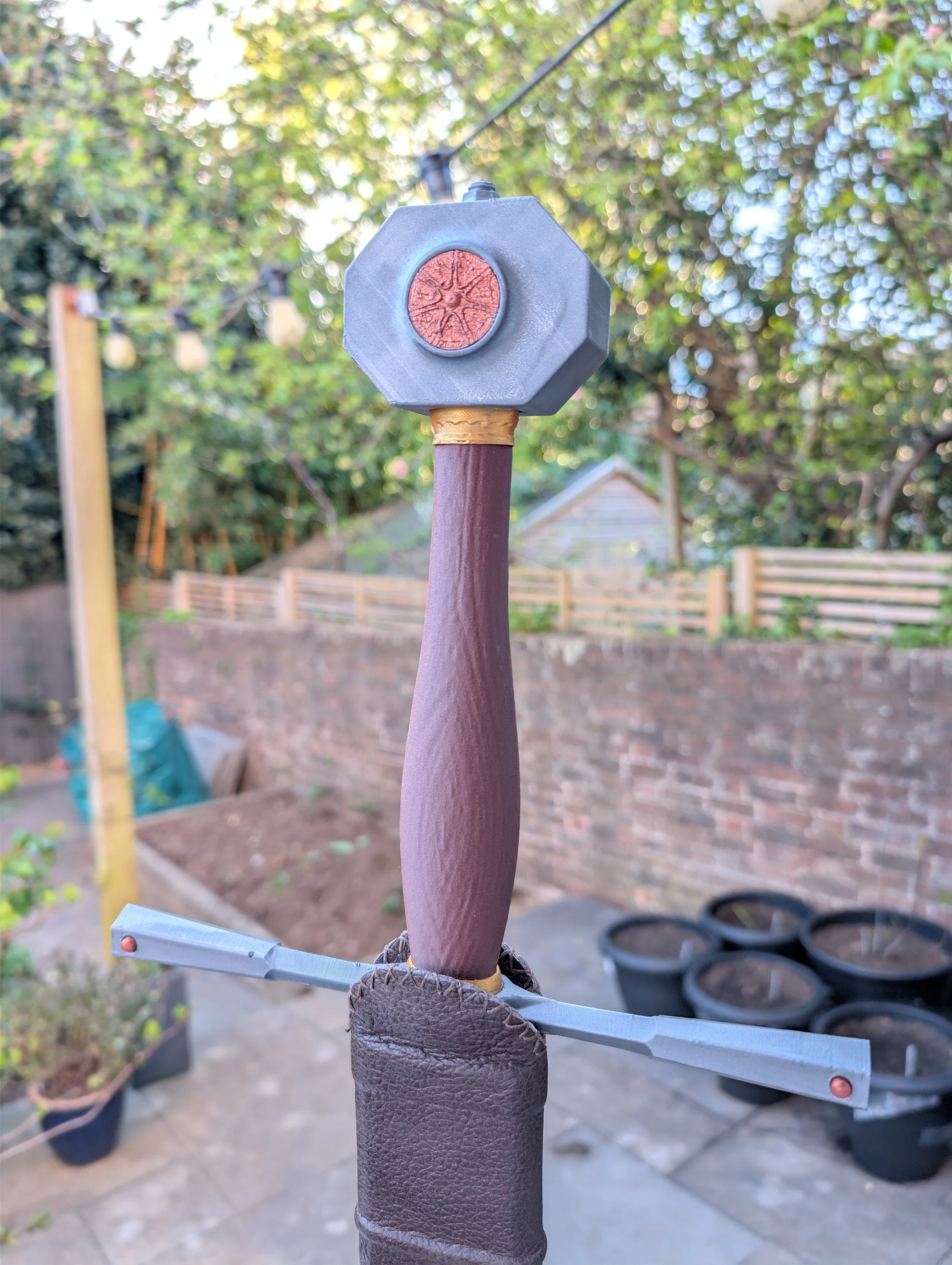 Sword hilt in leather scabbard, wood effect grip, painted aspects and assembled together using dowel through length for strength