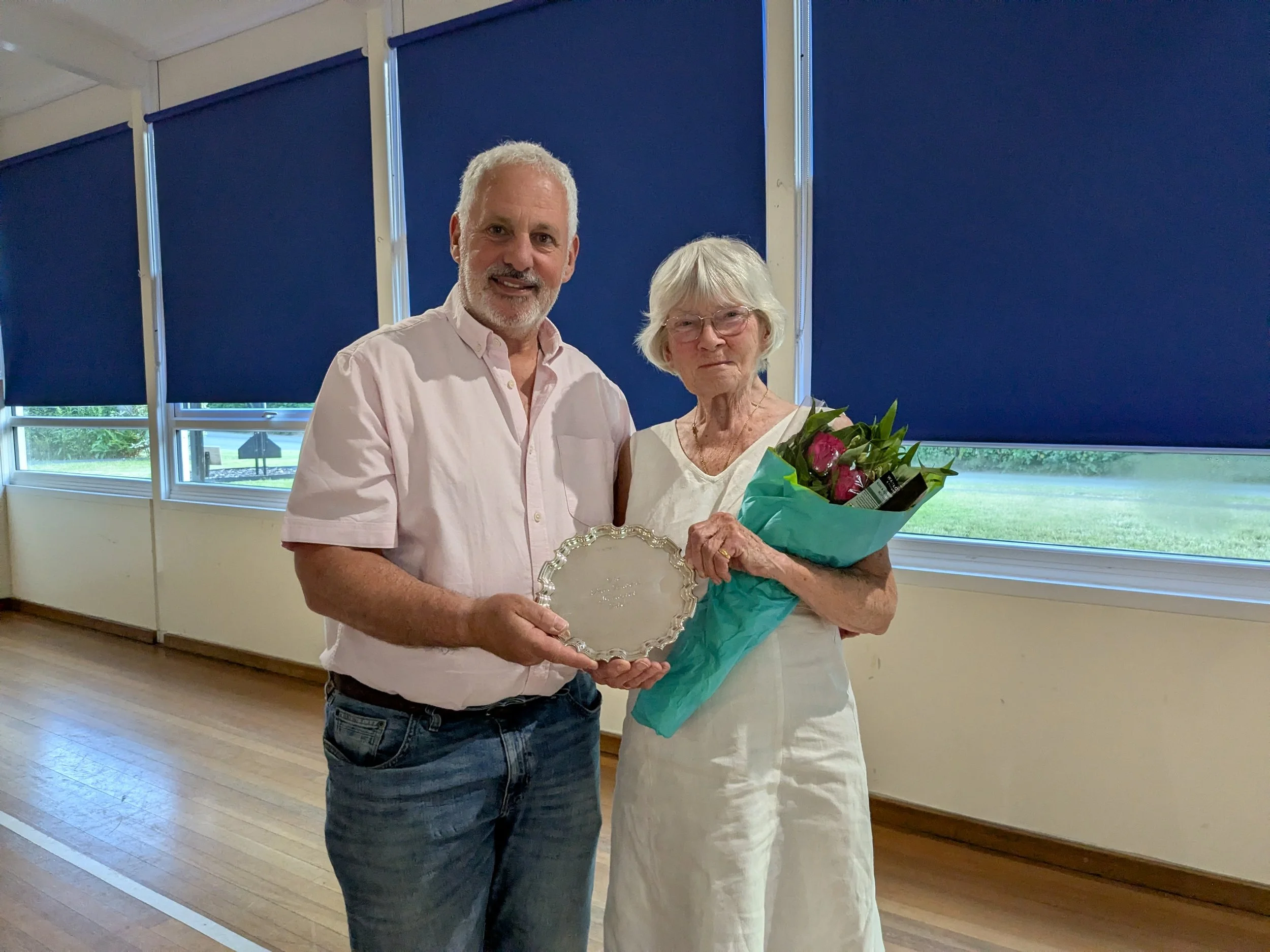 Woman being presented with salver and flowers by a man