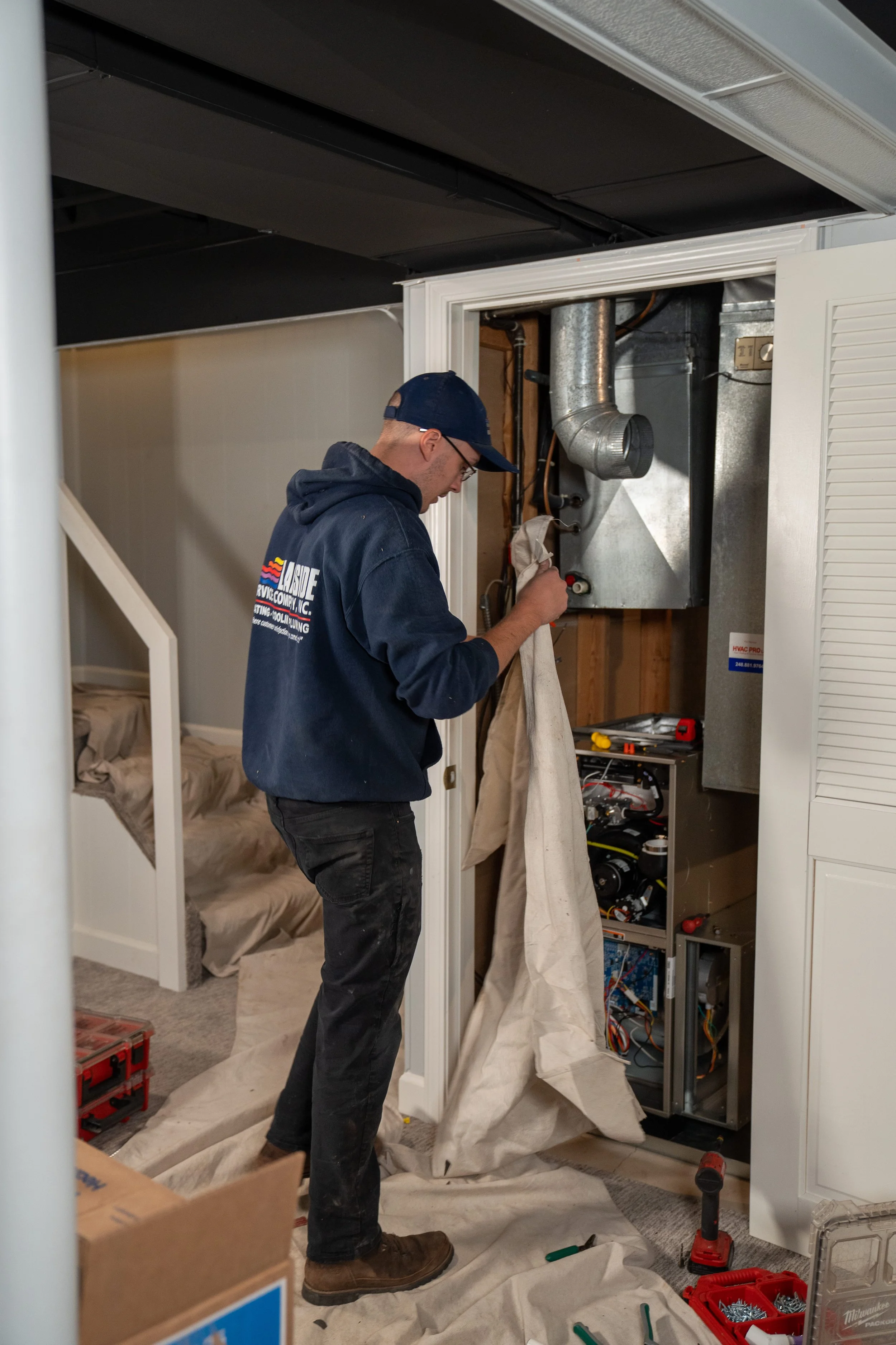 Lakeside technician installing a new furnace in a Michigan home