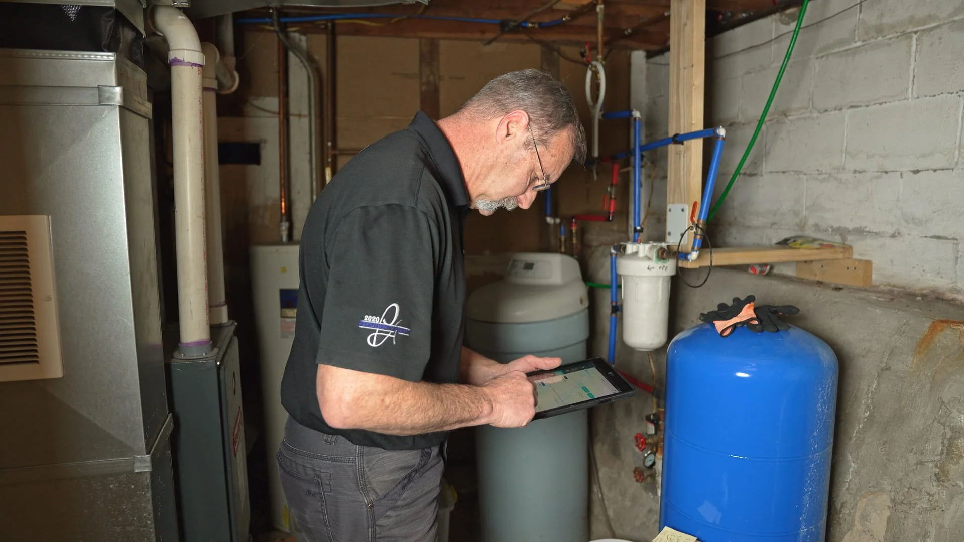 Lakeside technician inspecting a home plumbing system with a tablet