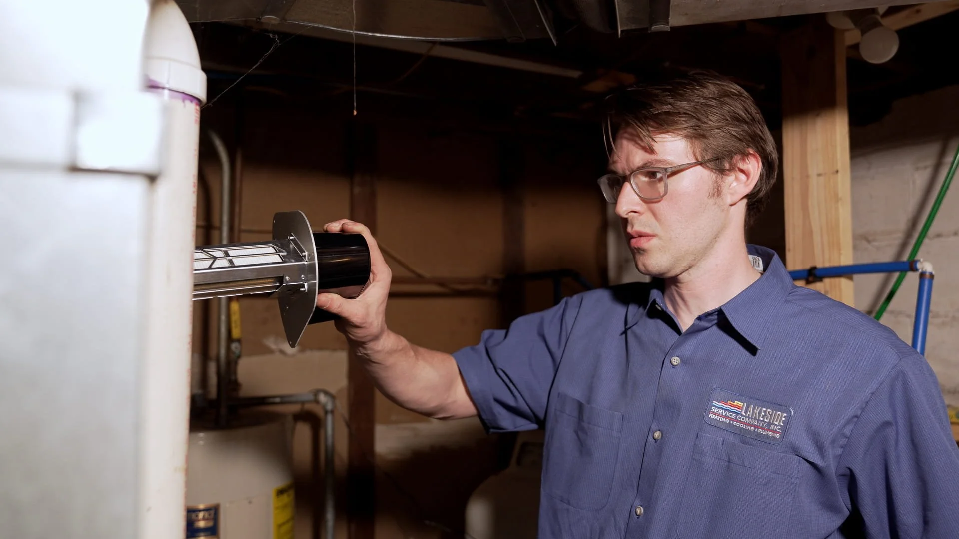 Lakeside technician installing a whole-home air filtration system