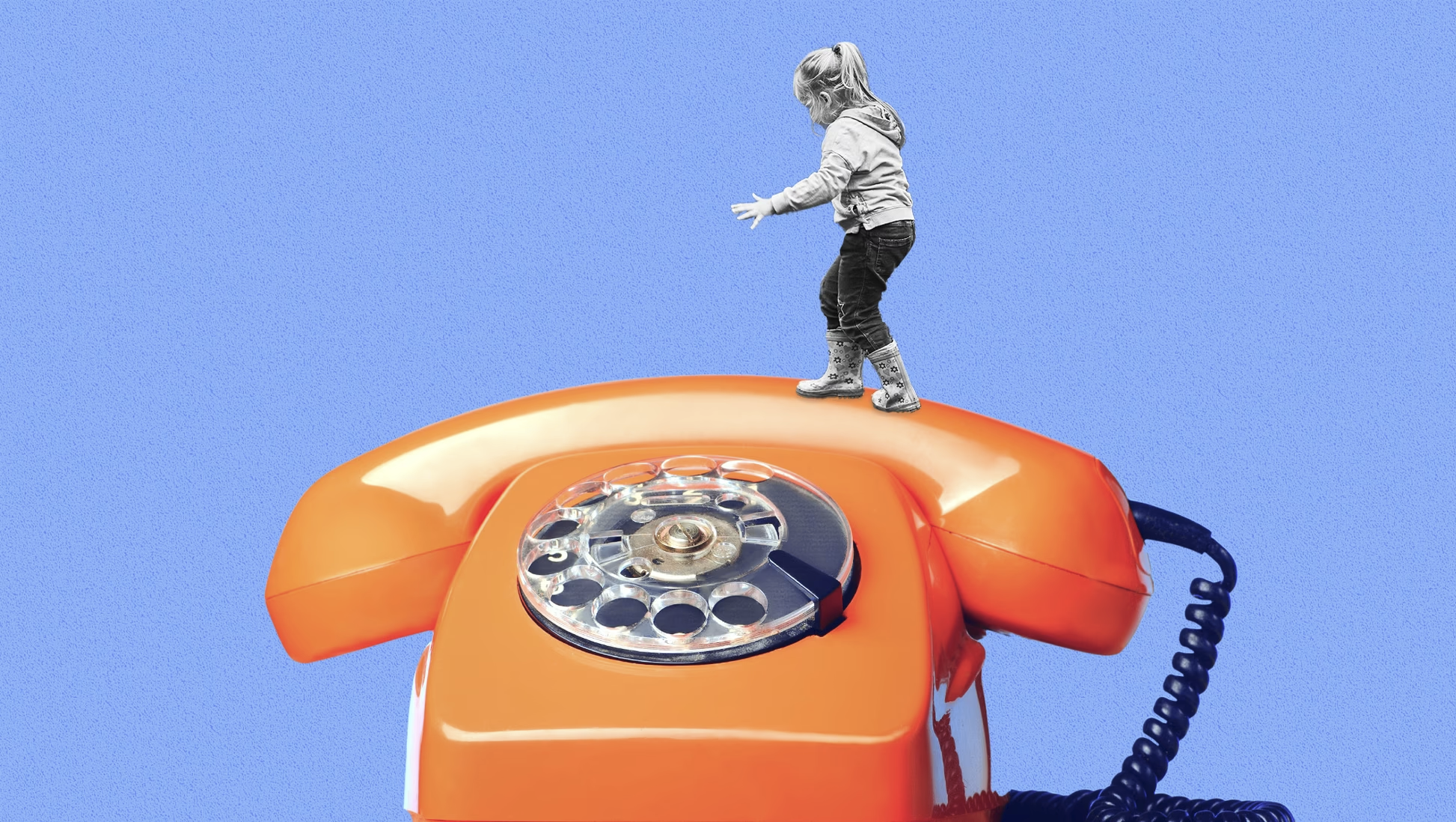 An orange rotary phone with child climbing on top