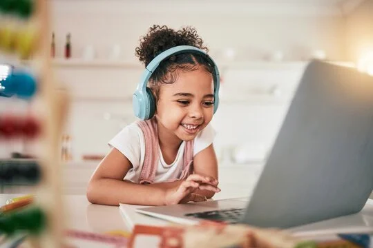 Young girl doing homework on laptop
