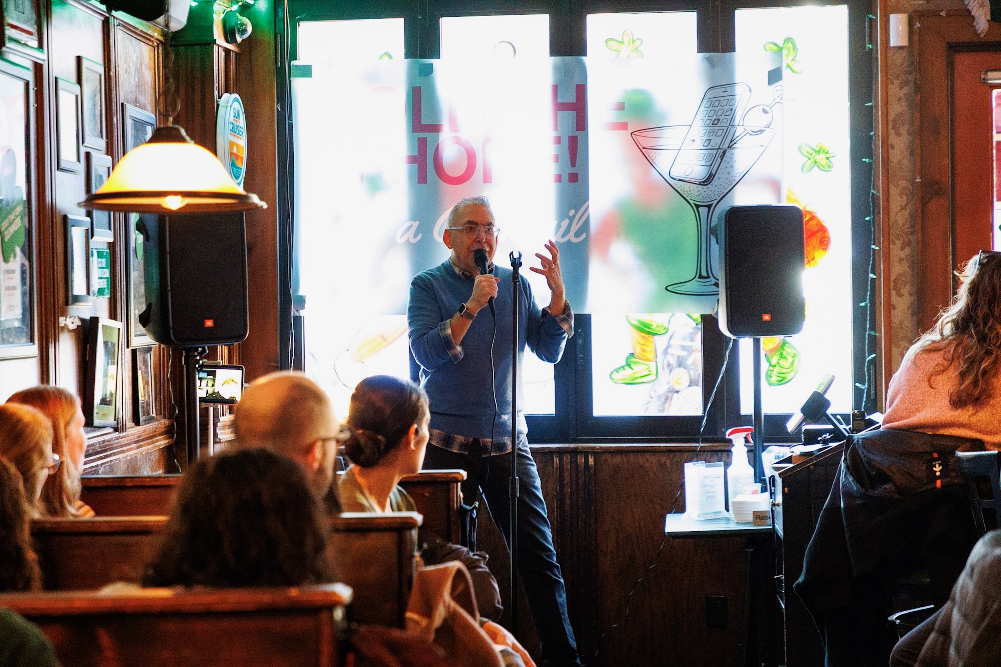 A man with a microphone addresses a crowd of onlookers