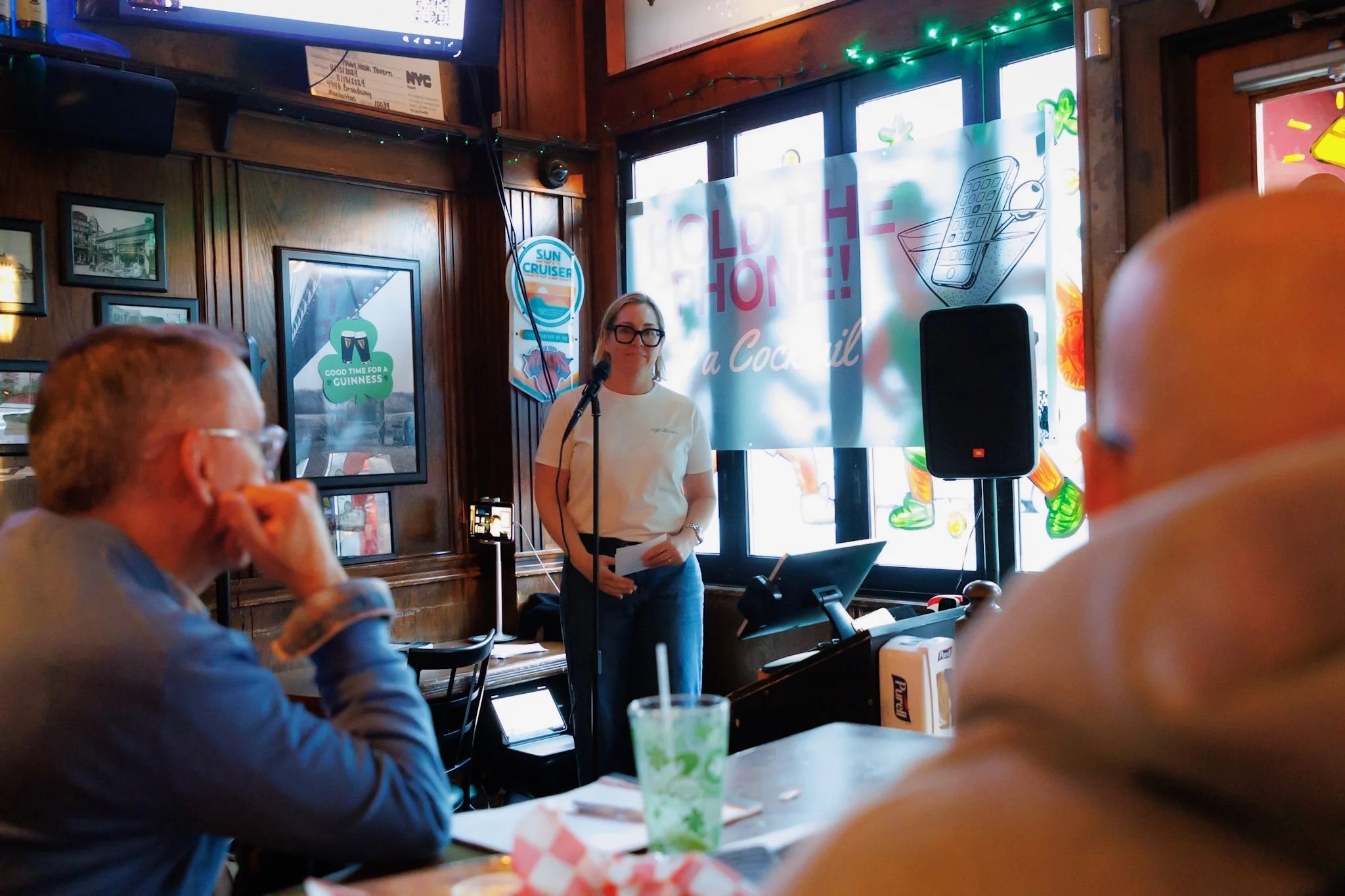 A woman at a microphones takes a question from the crowd