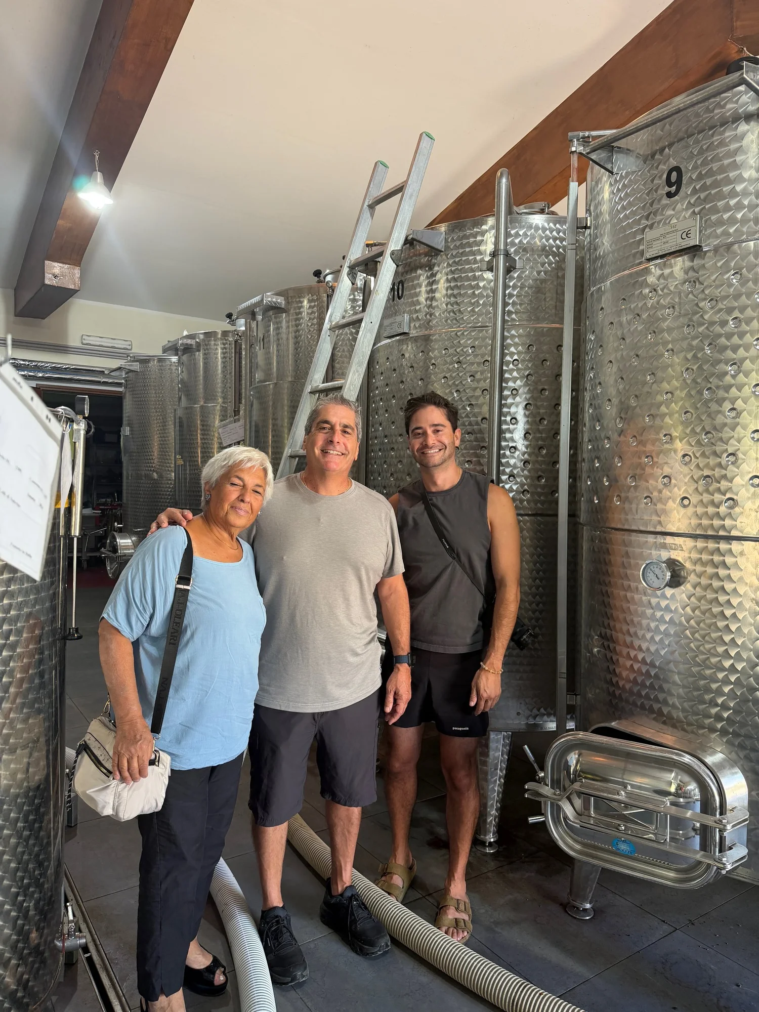 Three people at the steel tanks in the Firosa cantina