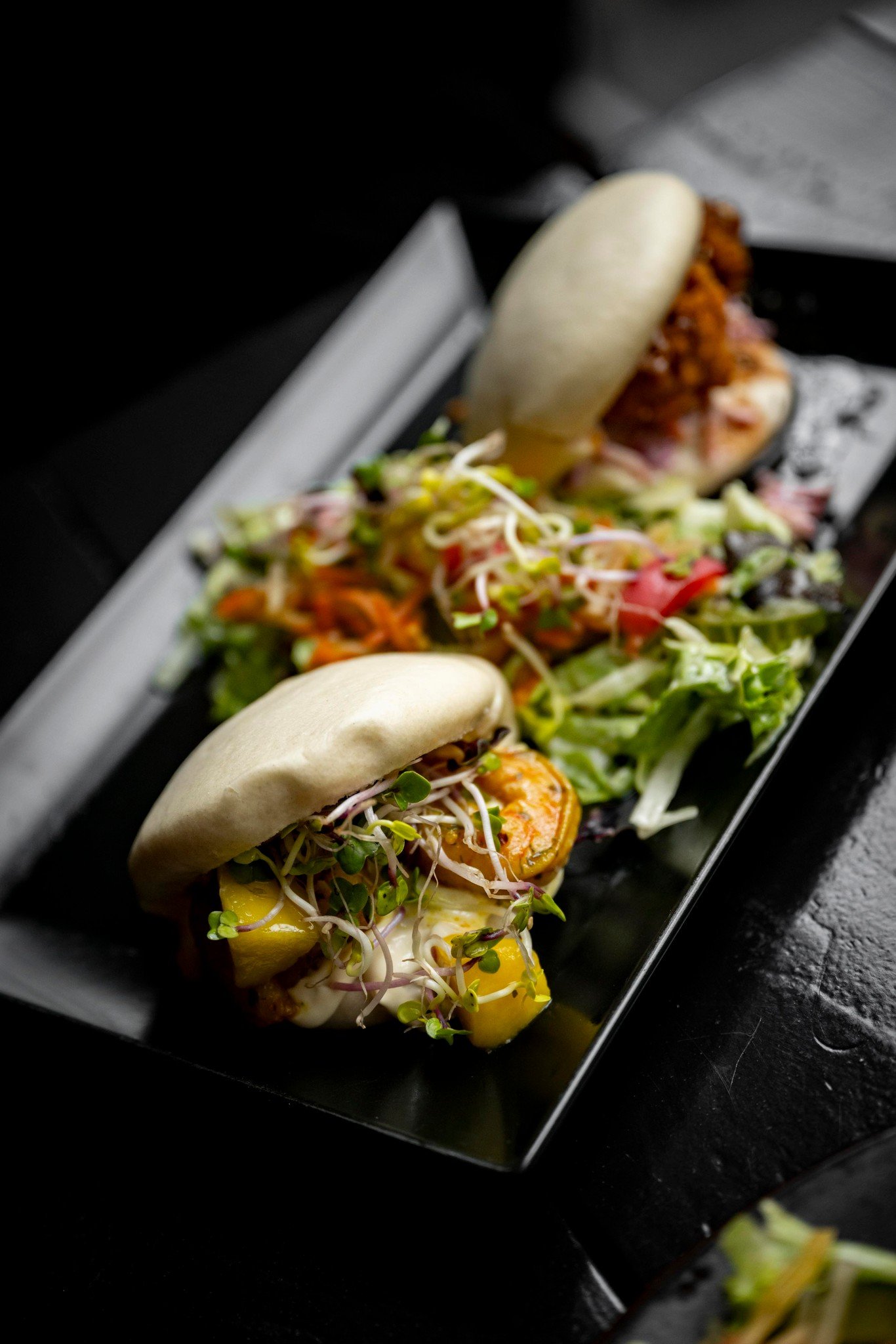 Bijblijven doe je door even van wereld te wisselen.

Na een oer-Hollandse Koningsdag stappen we zo een andere smaakwereld in. Onze gua bao buns brengen je verder dan je verwacht. Zacht gestoomde broodjes met sticky karaage chicken, frisse coleslaw, T