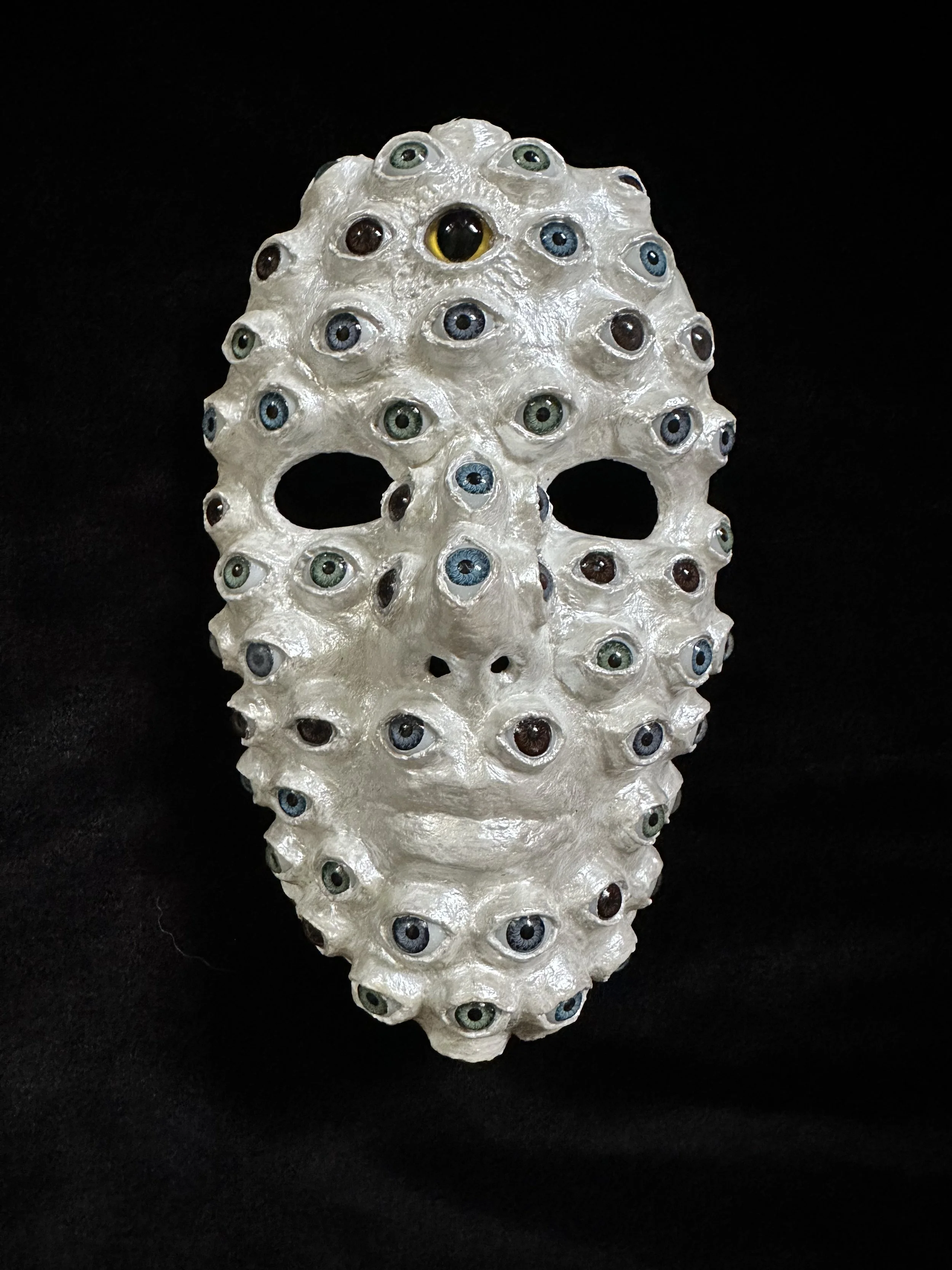 "The Watcher", Laura Nelsen, papier-mâché clay, acrylic doll eyes and acrylic paint, 8"x5"x3", 2026.