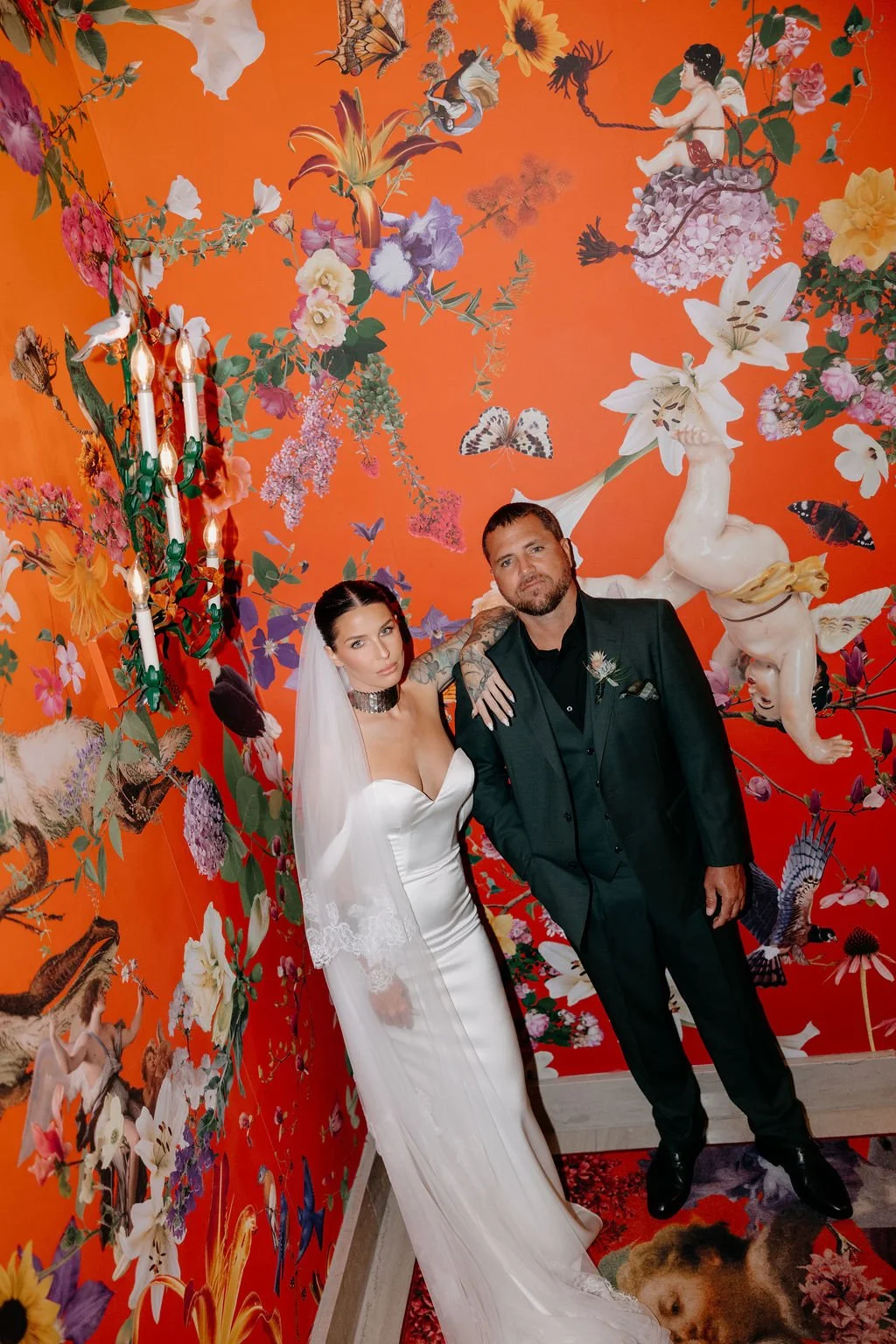 Kori and Pierrick together against a vivid floral backdrop