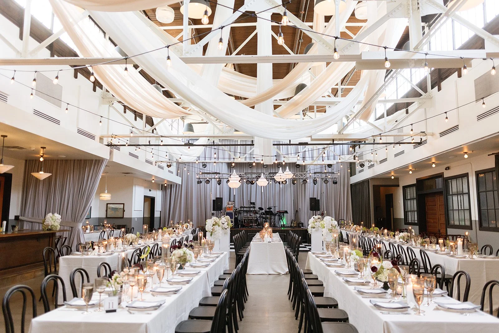 Candlelit reception tables and white draping at Christina and Jake’s wedding