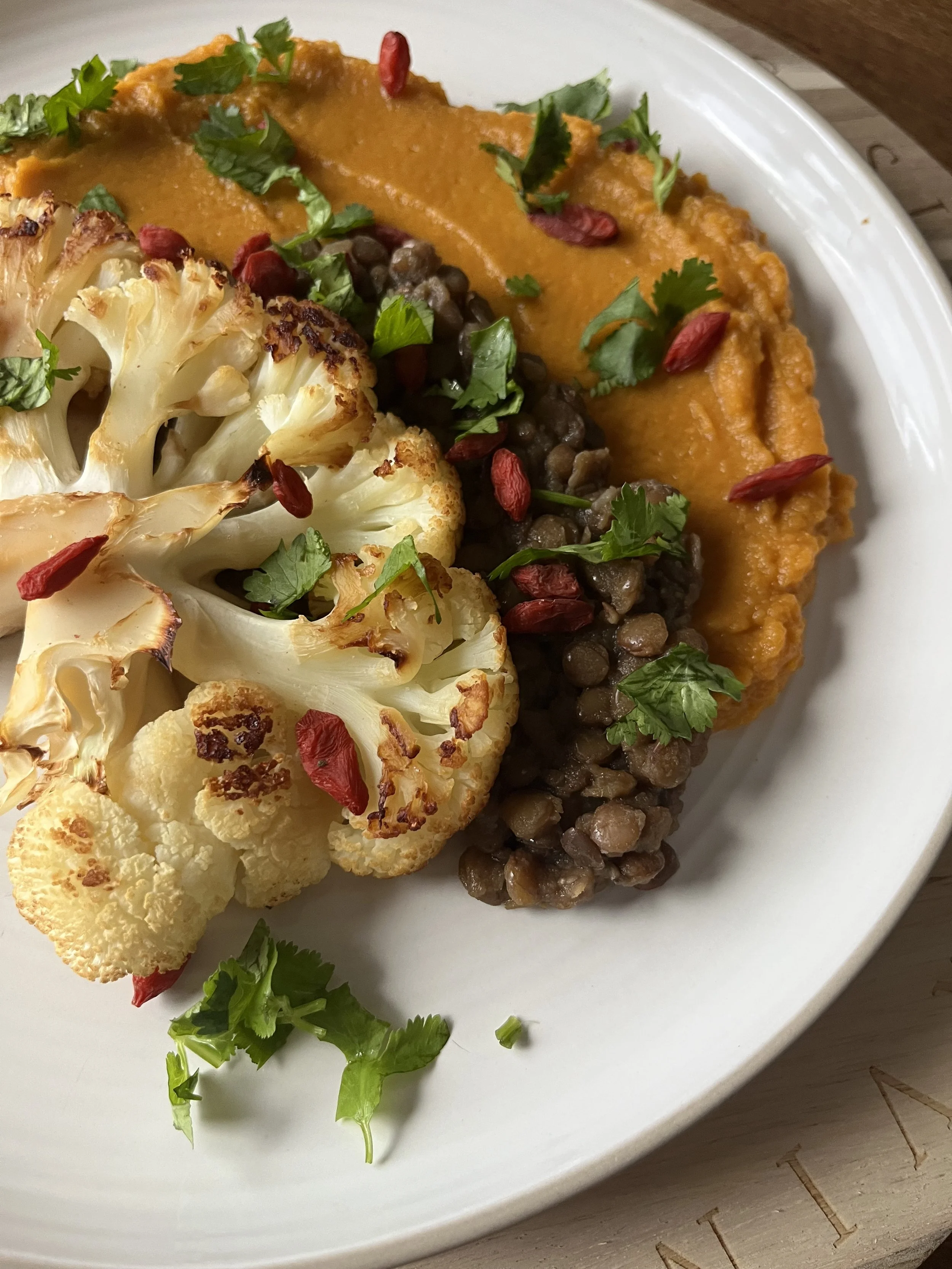 Roasted cauliflower on a bed of stewed lentils and creamy sweet potato  