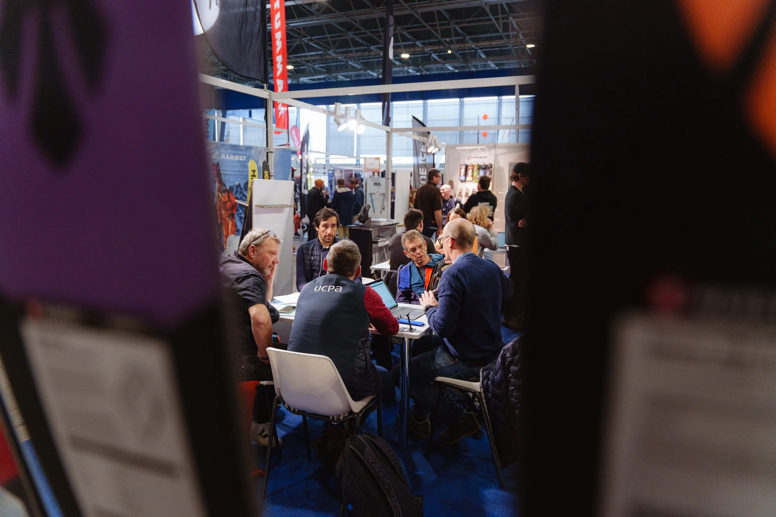 Groupe de personnes assises autour d'une table lors d'un événement ou d'une conférence.