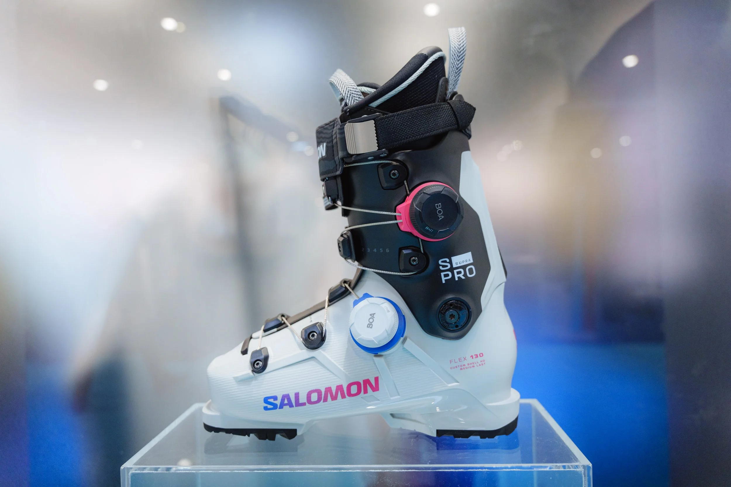 Chaussure de ski Salomon S/Pro exposée sur un support transparent.