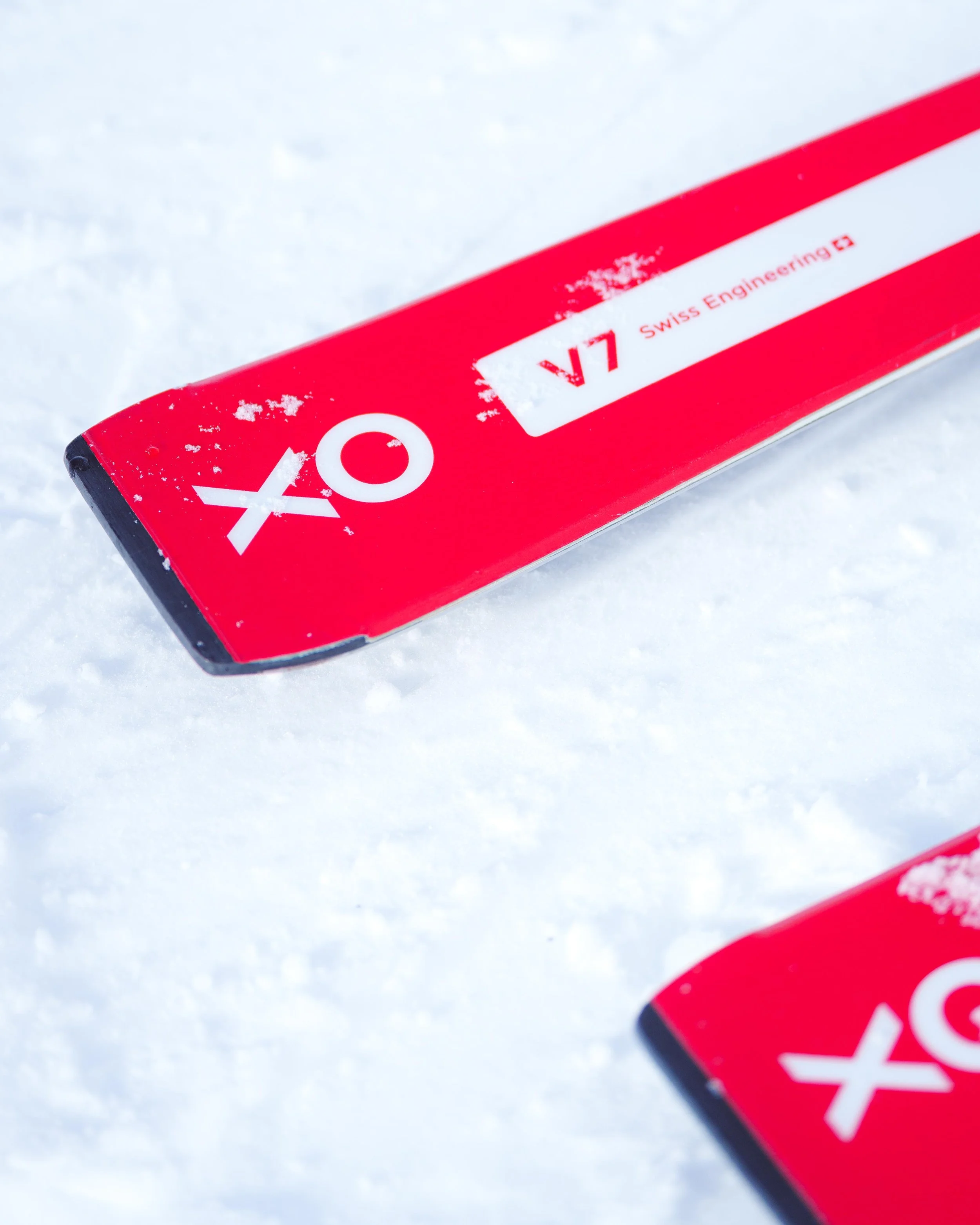 Skis rouges sur neige avec texte "XO V7 Swiss Engineering".
