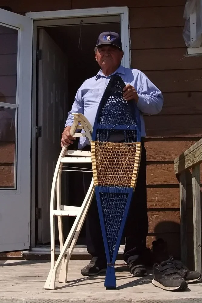 A First Nations male elder holding his home-made traditional hunting snowshoes, Webequie First Nation, Ontario, Canada.