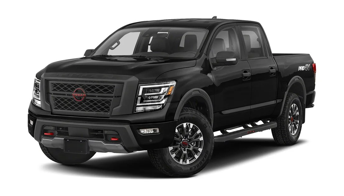 Black Nissan pickup truck with four doors, large grille, and rugged tires, viewed from front-left angle.