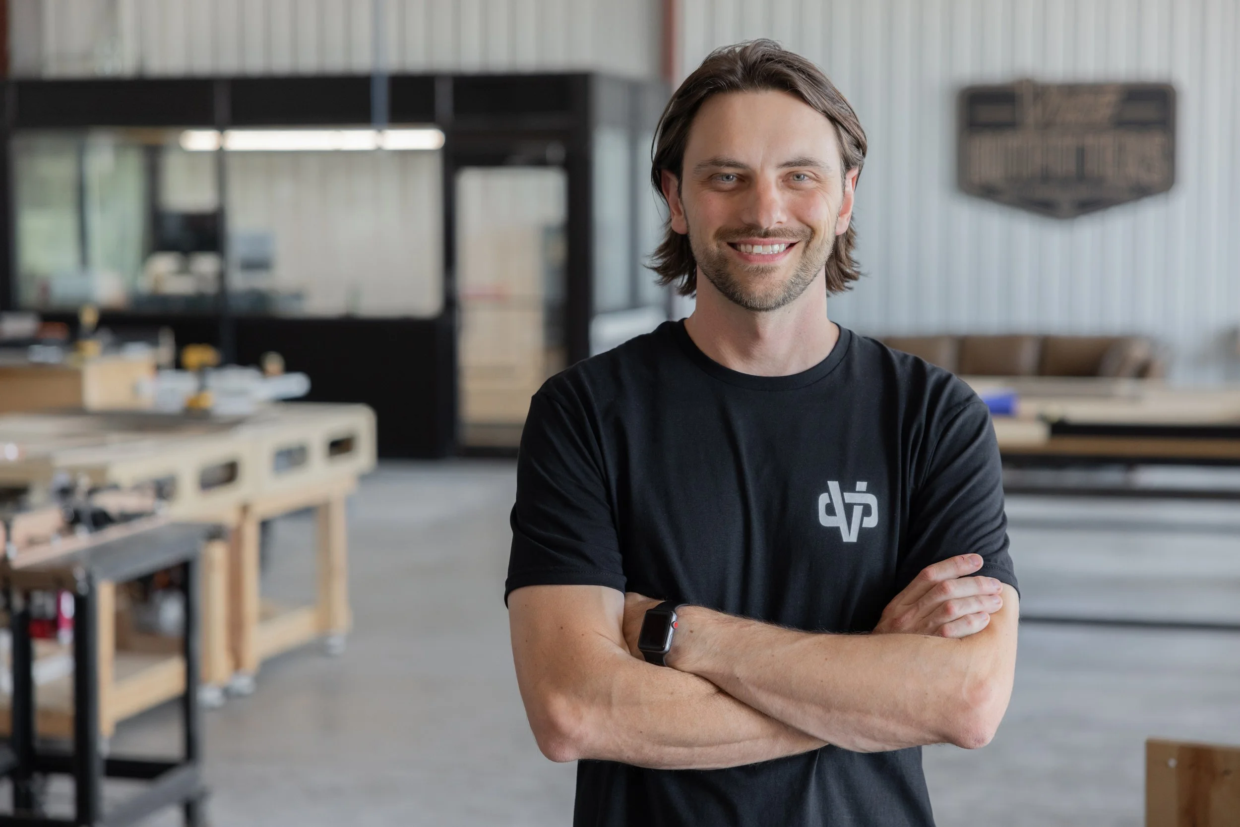 VICE Outfitters owner, Dustin Rogers, standing with arms crossed in the VICE Outfitters shop space.