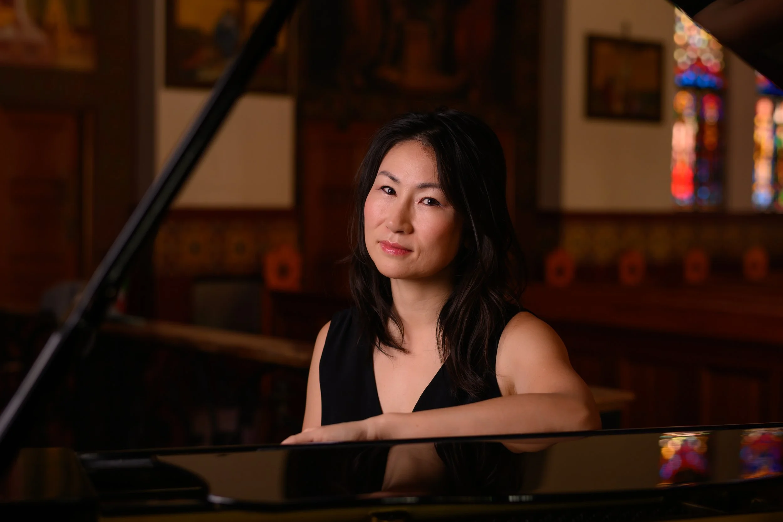 A korean girl sitting next to a piano