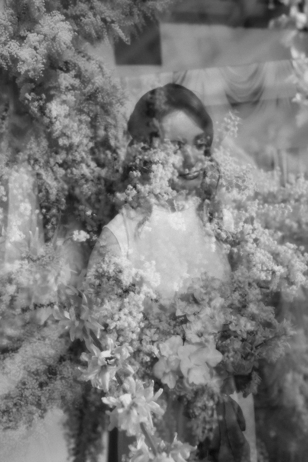Black and white double exposure image of a woman with flowers.