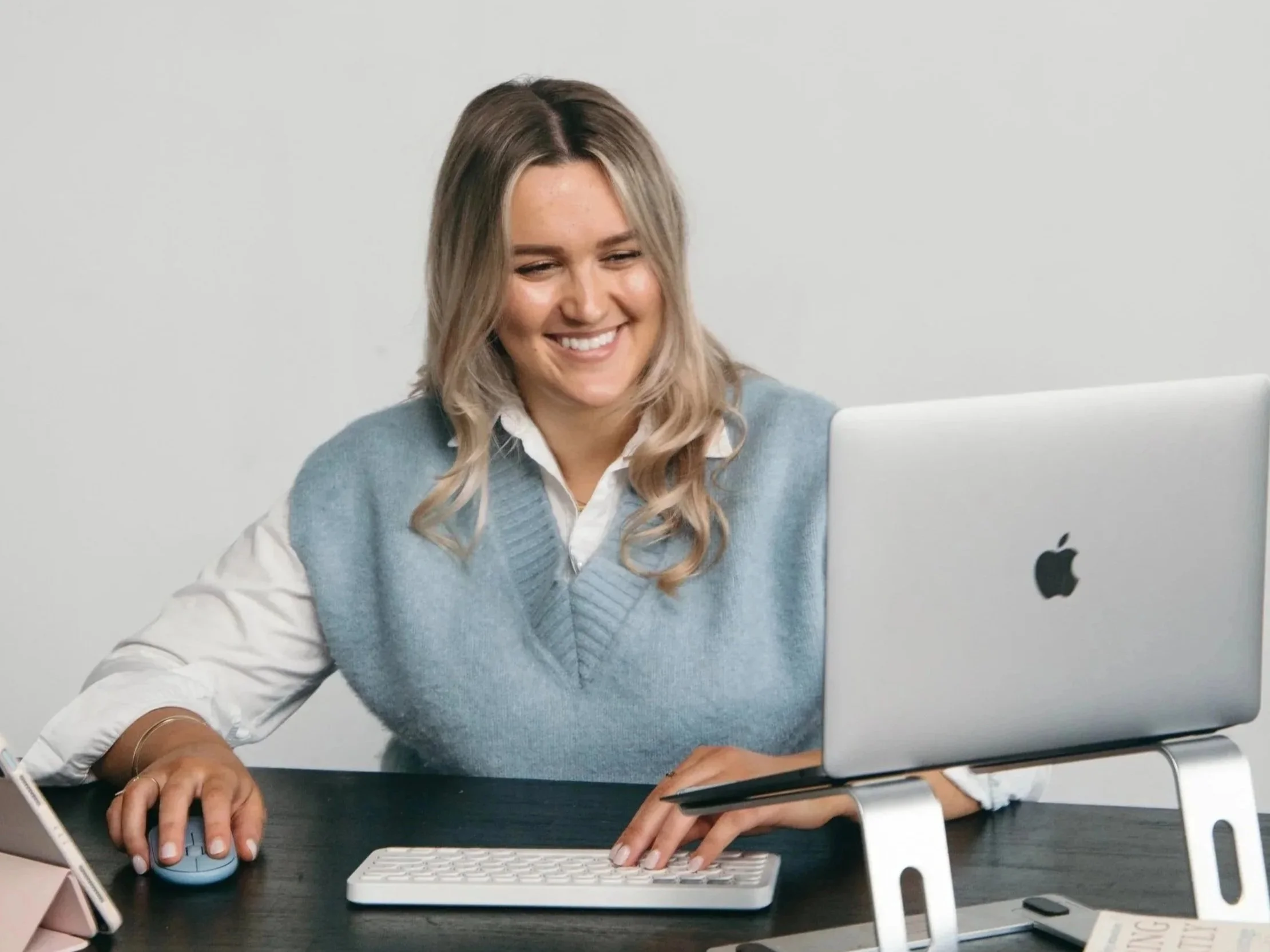 Back view of a woman with hair in a bun, wearing a sports bra, standing outdoors against a clear sky.