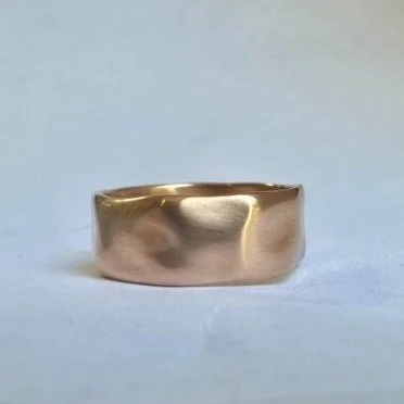 Gold-colored ring on a plain surface