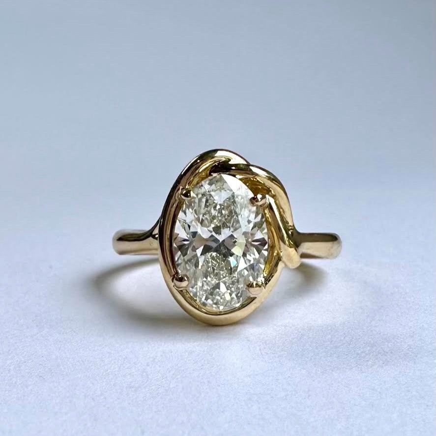 Gold ring with an oval-shaped diamond centerpiece