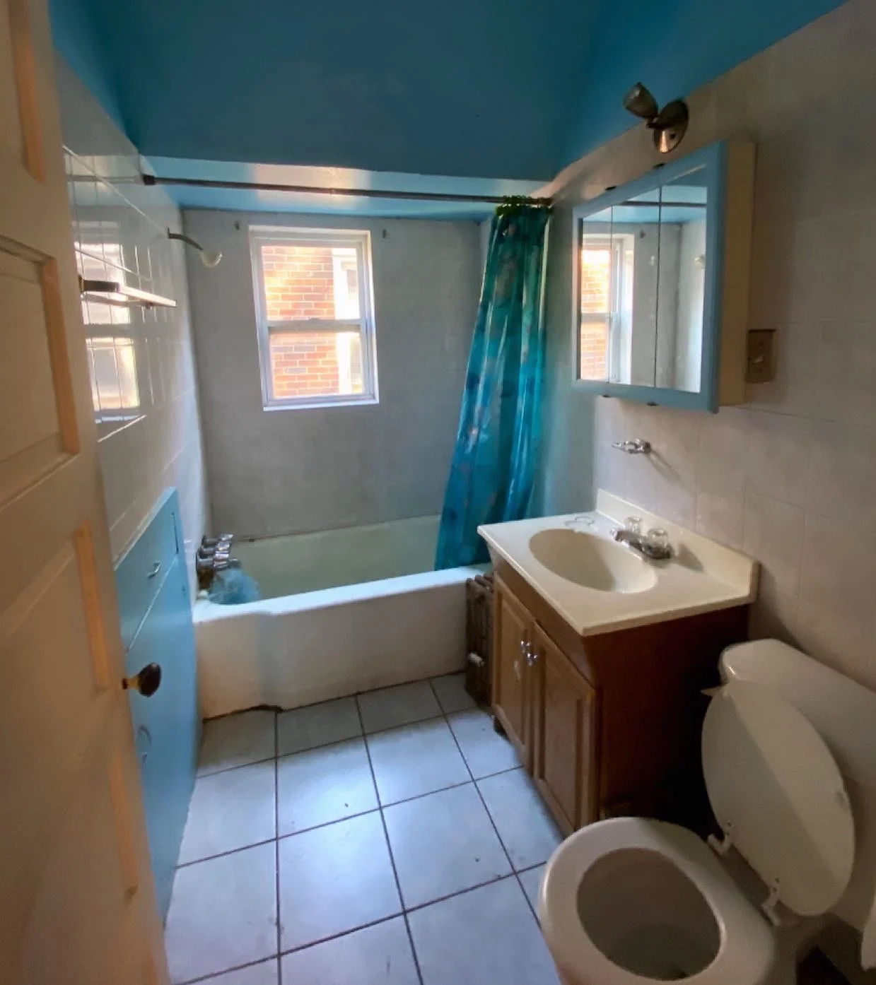 Old bathroom with blue walls and tile. 