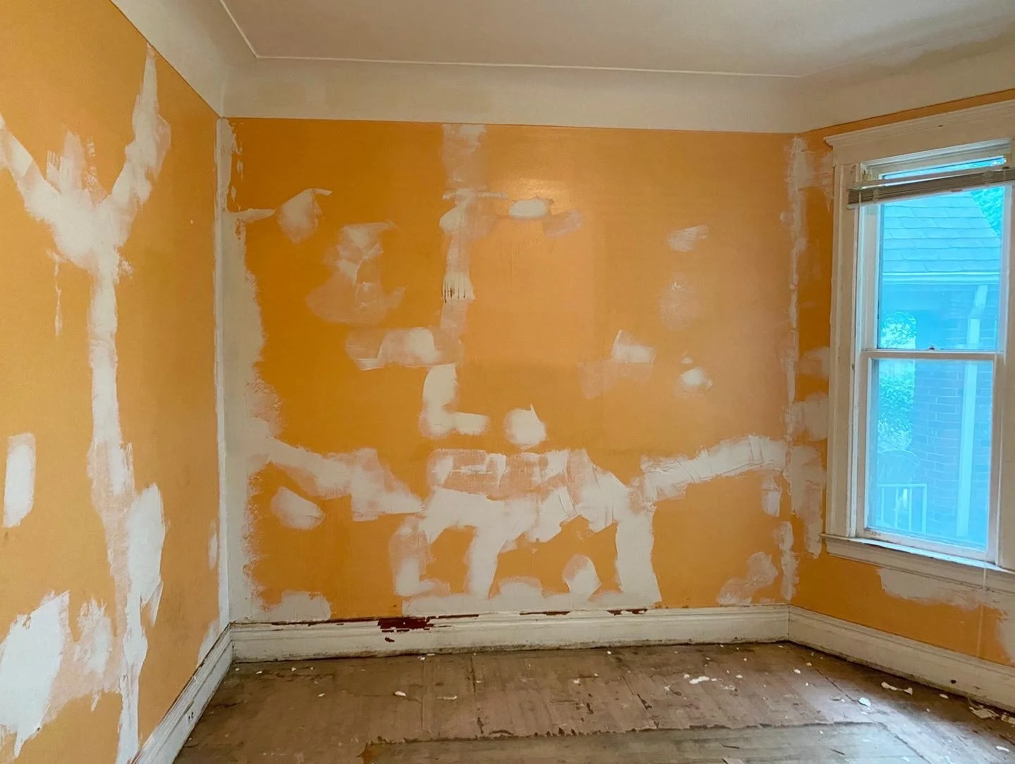 Damaged plaster walls that are orange with broken plaster. 
