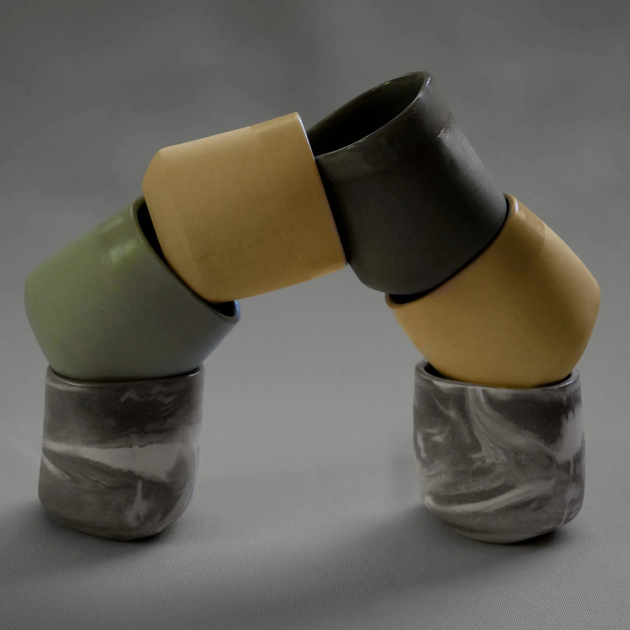 An Arch of geometric cups in marbled stone, moss, desert, stone. These cups can be used as baby chino cups of espresso cups