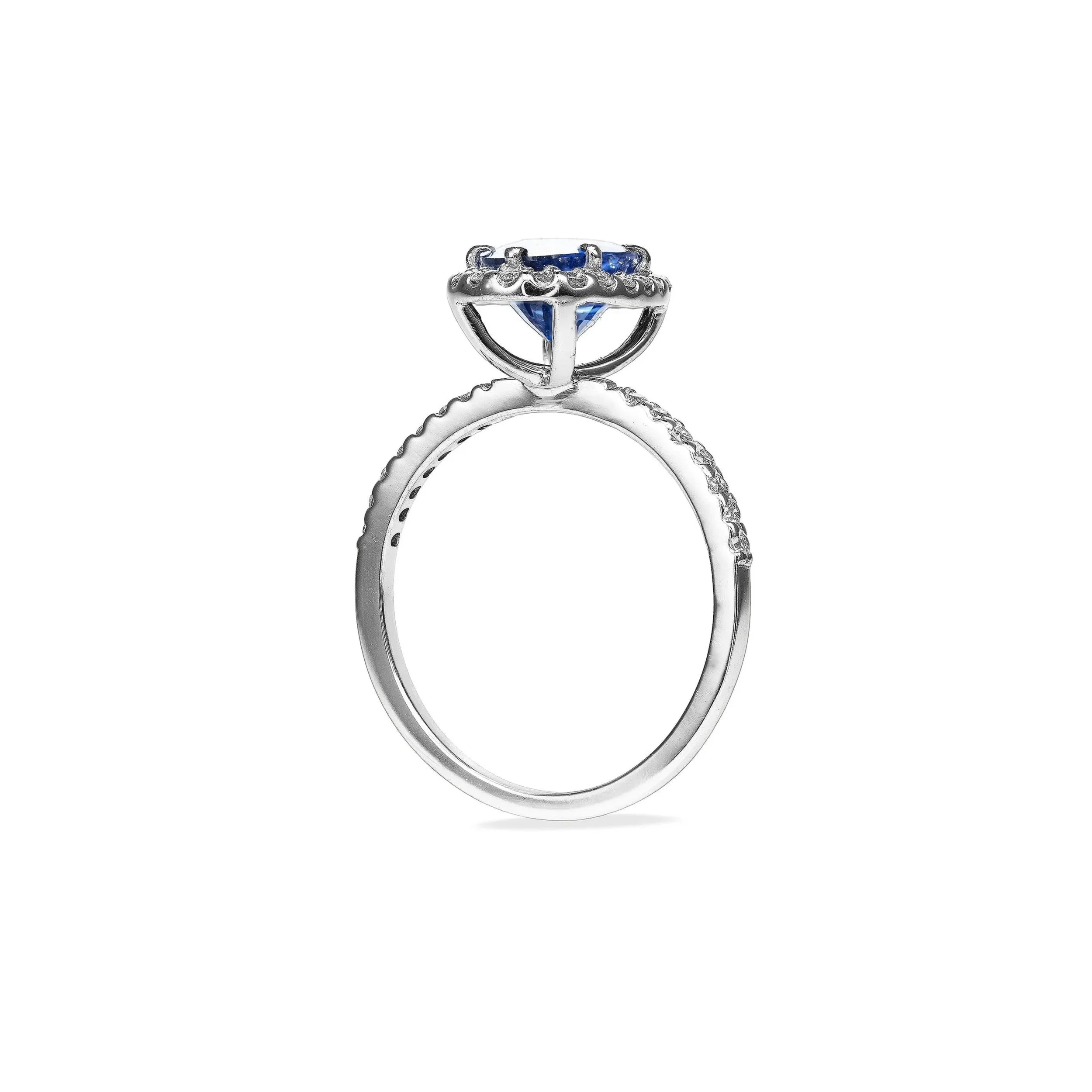 Close-up of a silver ring with a large blue gemstone set in a decorative setting, displayed against a plain white background.
