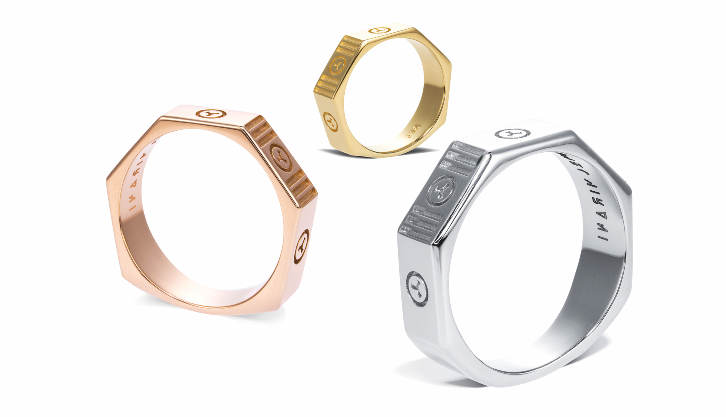 Three rings in gold, rose gold, and silver, with engraved logos and designs, arranged on a white background.