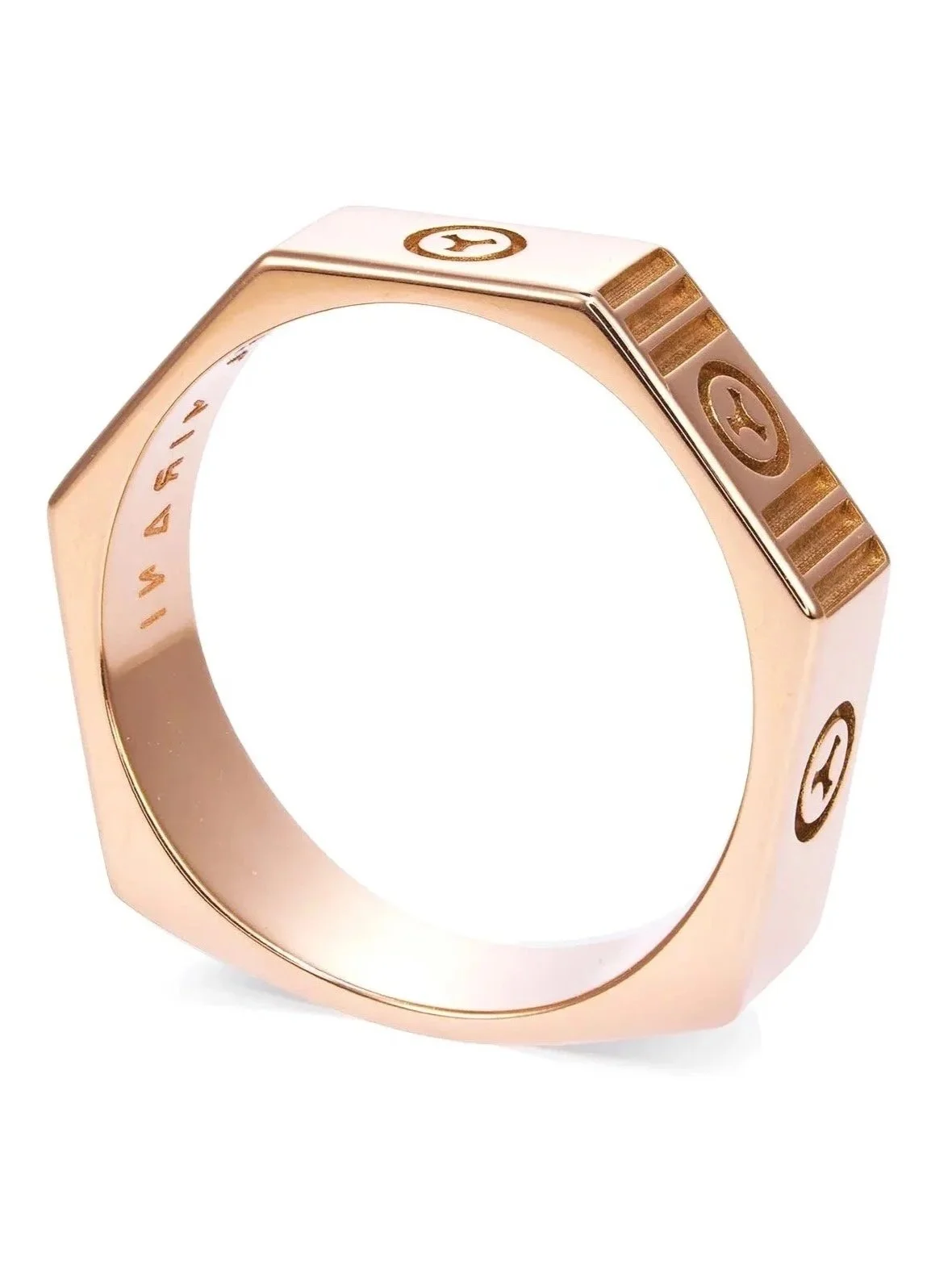 A rose gold ring with engraved symbols and a unique geometric shape design.
