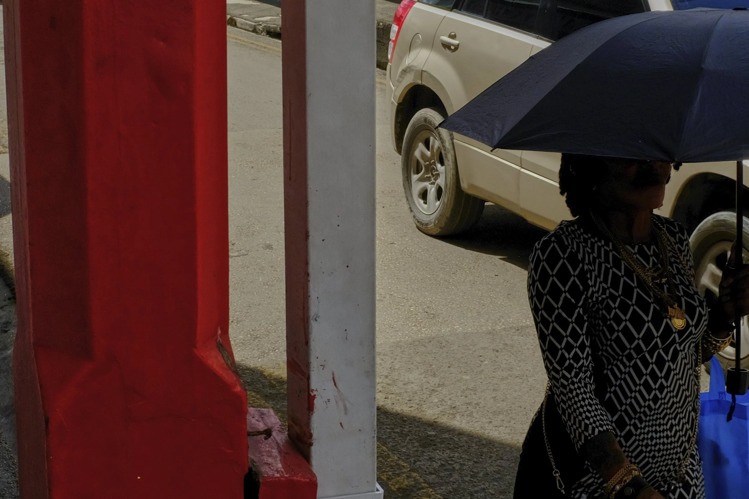 woman with umbrella by red post.jpg