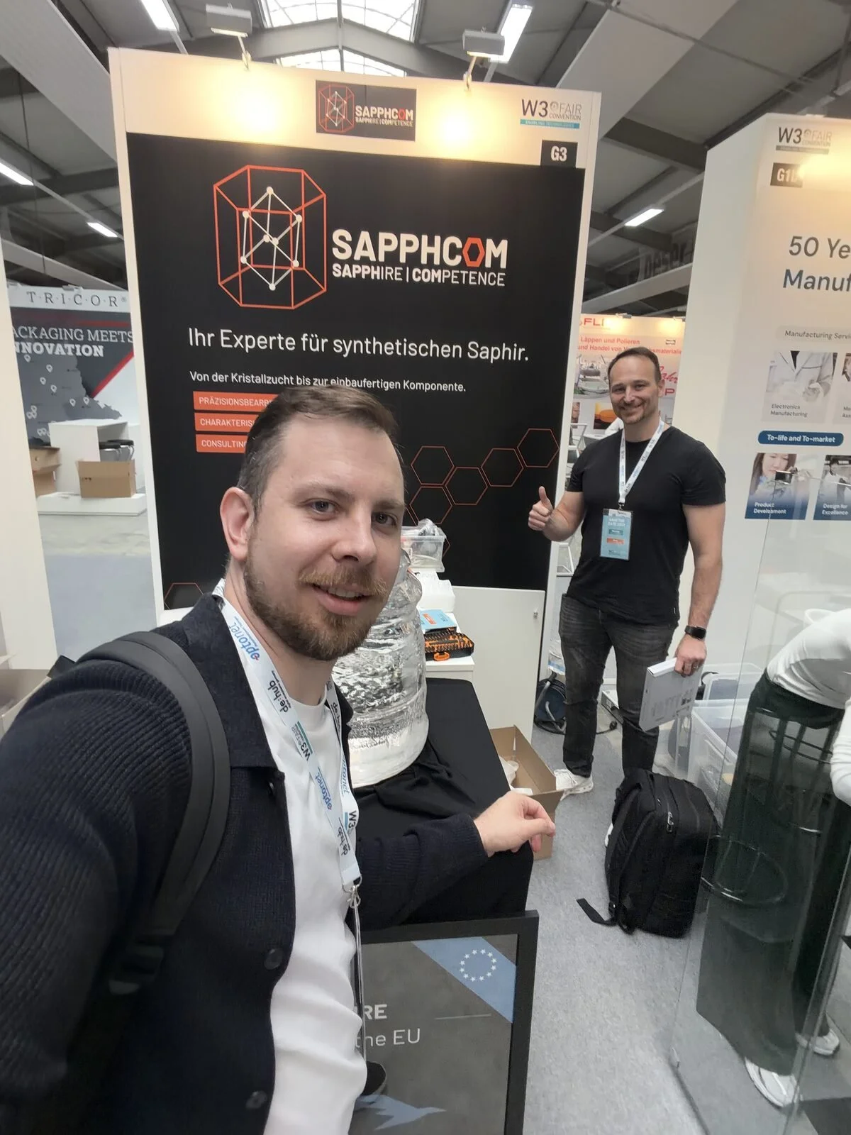 Sebastian Löslein and Matejs Balodis at the SAPPHCOM booth with Falcon Sapphire’s 100 kg Kyropoulos boule during W3+ Fair Jena.