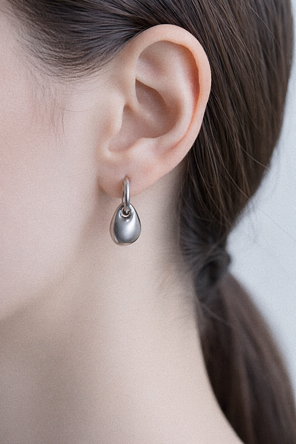 Silver teardrop earring close-up.png
