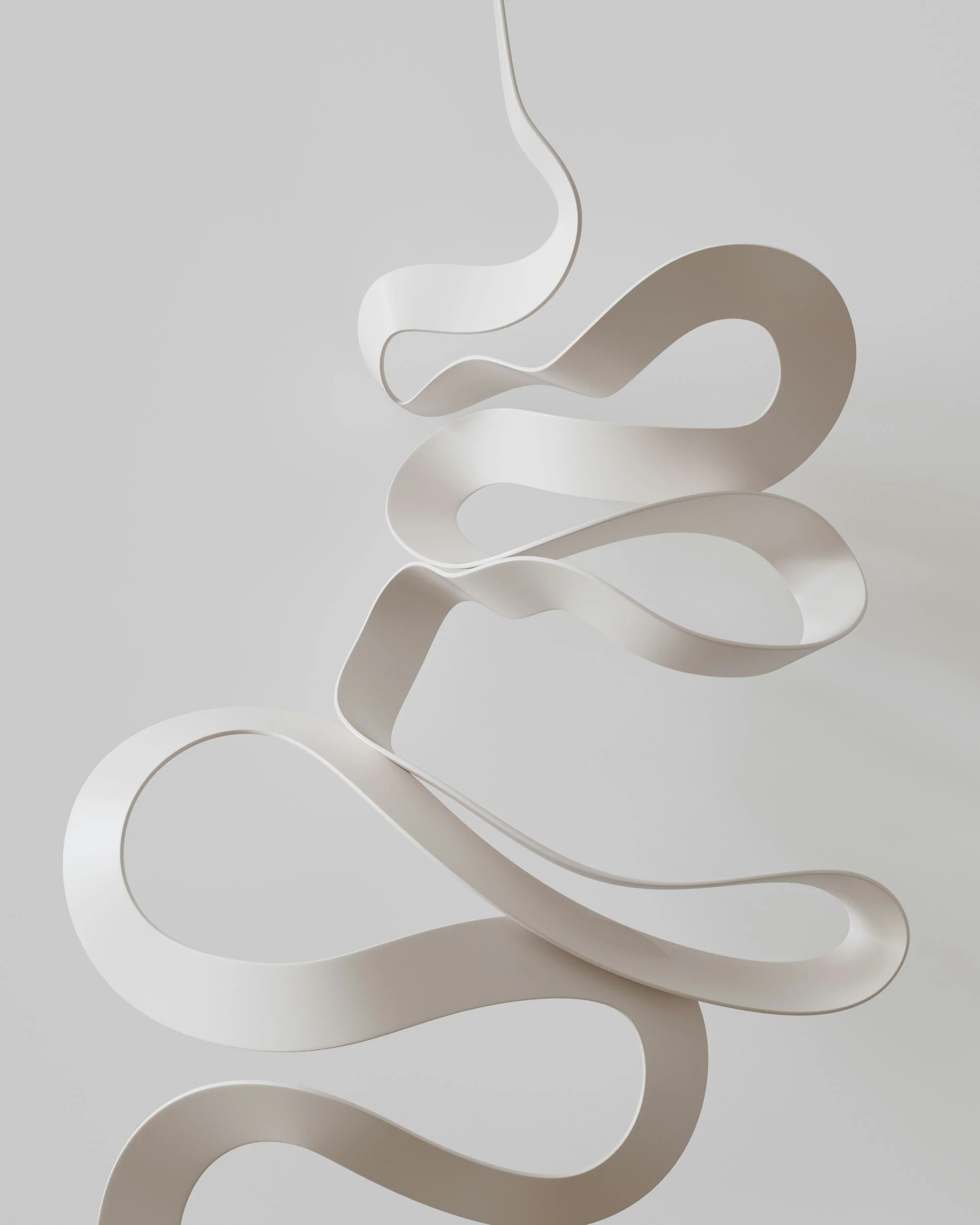 A white, abstract, curved sculpture with multiple loops and swirls, positioned on a white surface against a plain grey background.