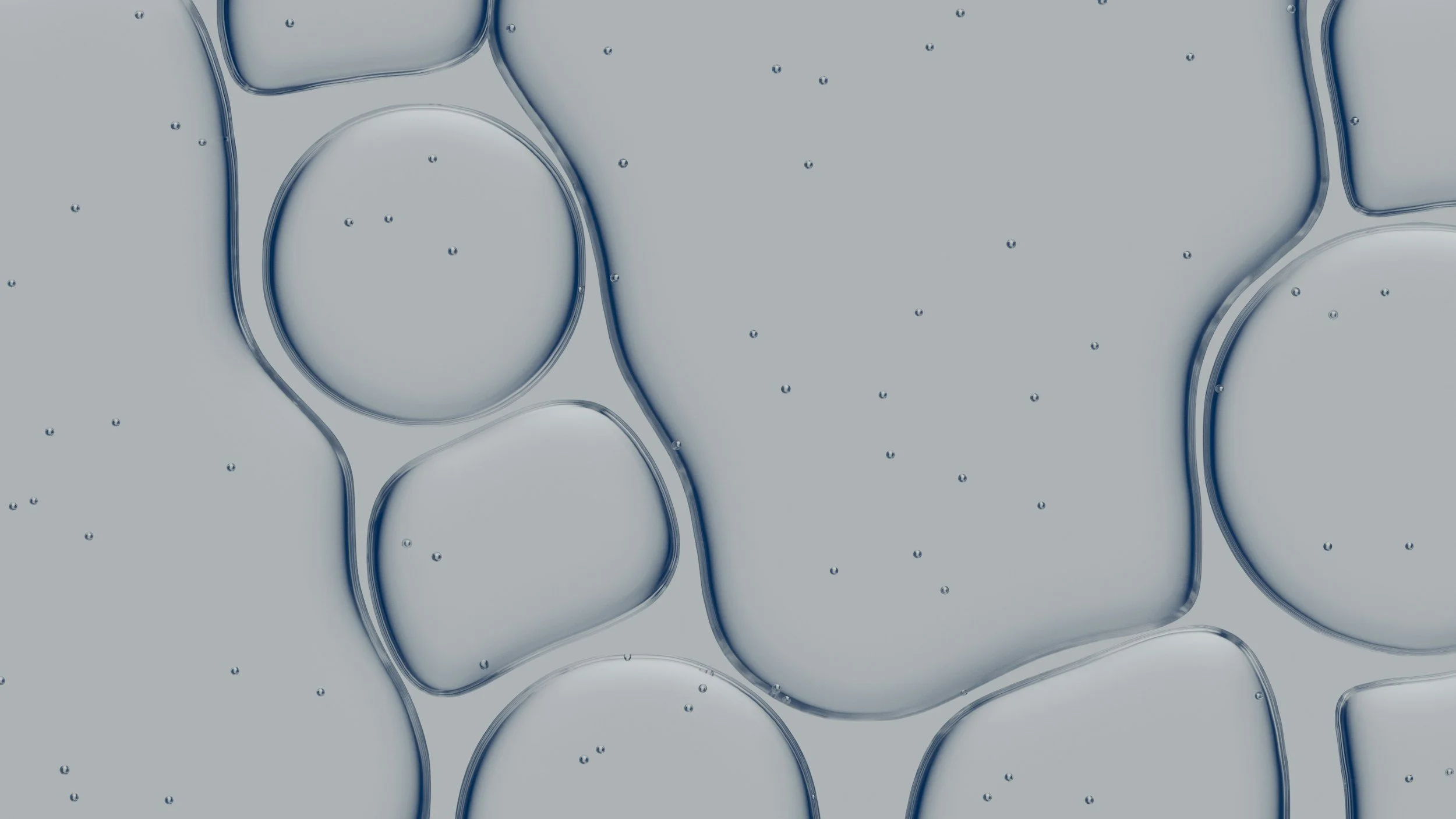 Close-up of several transparent ice cubes with visible water bubbles on a gray background.