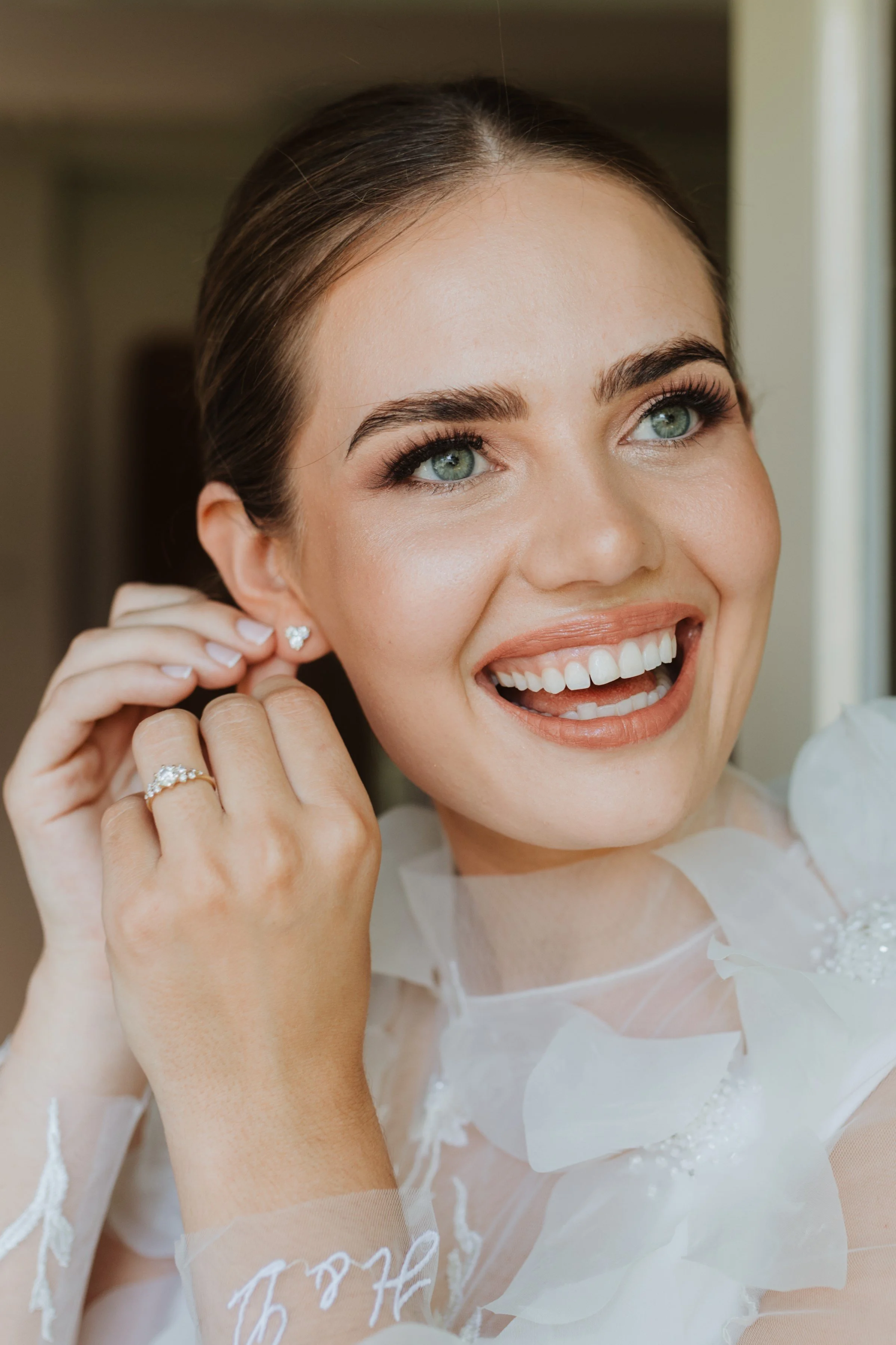 Bride with polished bridal makeup and softly styled hair on her wedding day.
