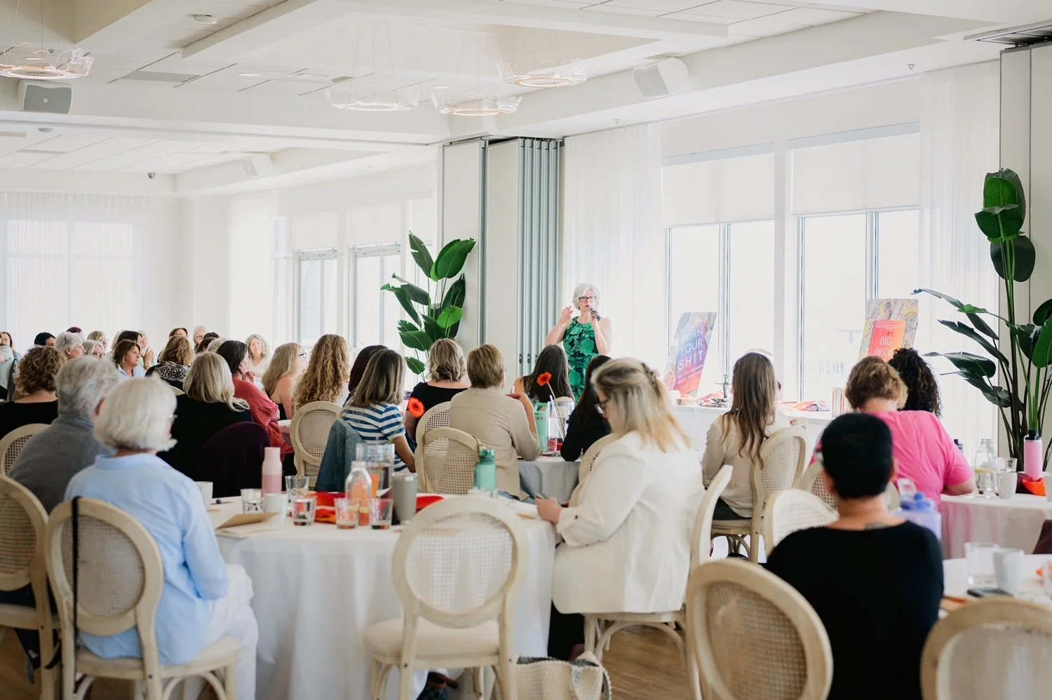 Lori Dyan speaking to a large audience at a live event