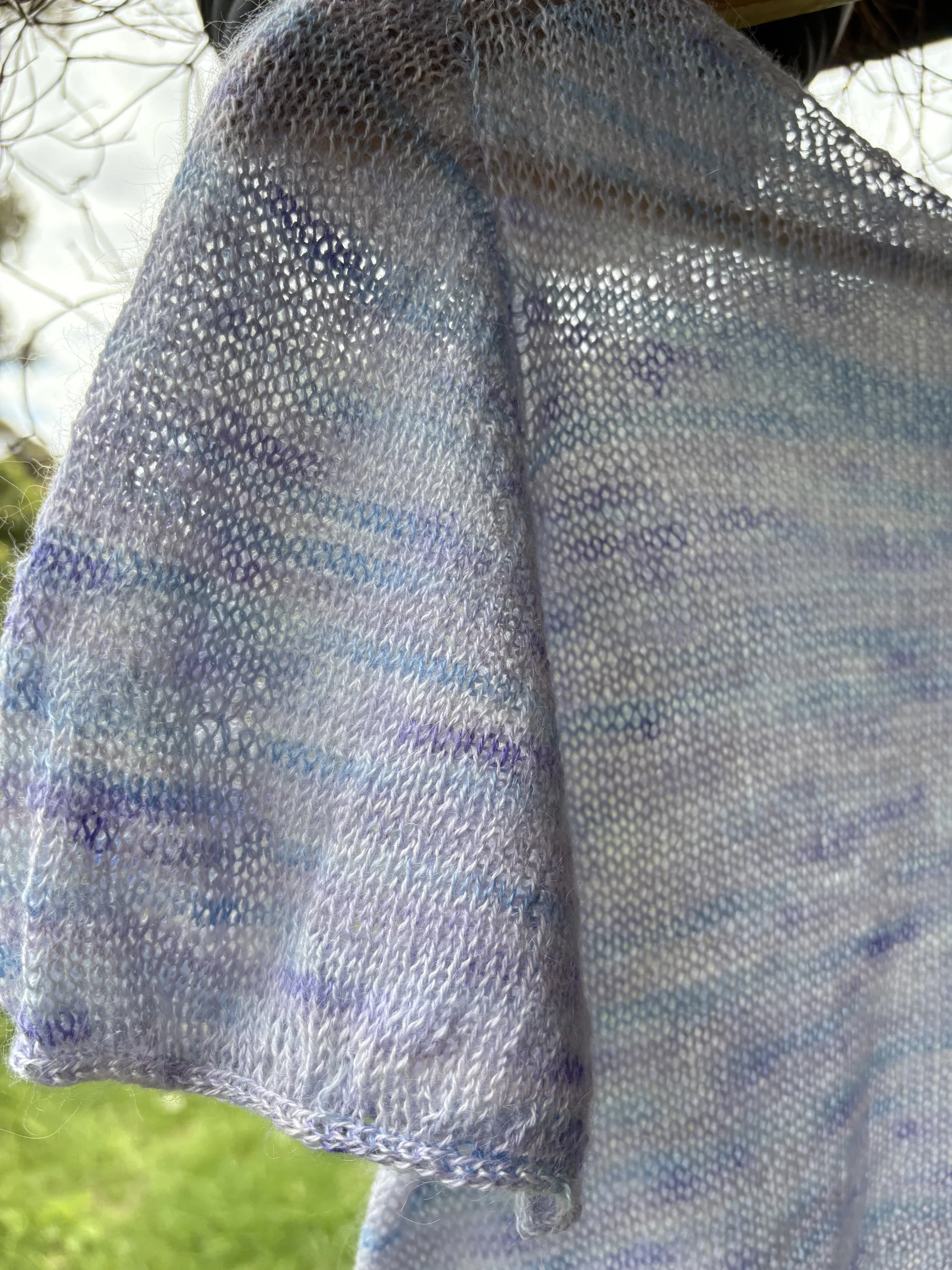 Close-up of a colorful, iridescent mesh fabric hanging outdoors.