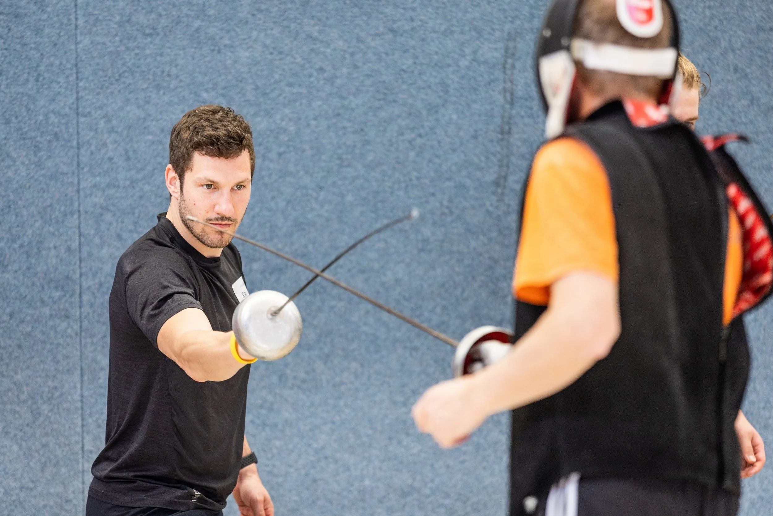 Zwei Männer stehen sich gegenüber und haben einen Fechtdegen in der Hand. 
